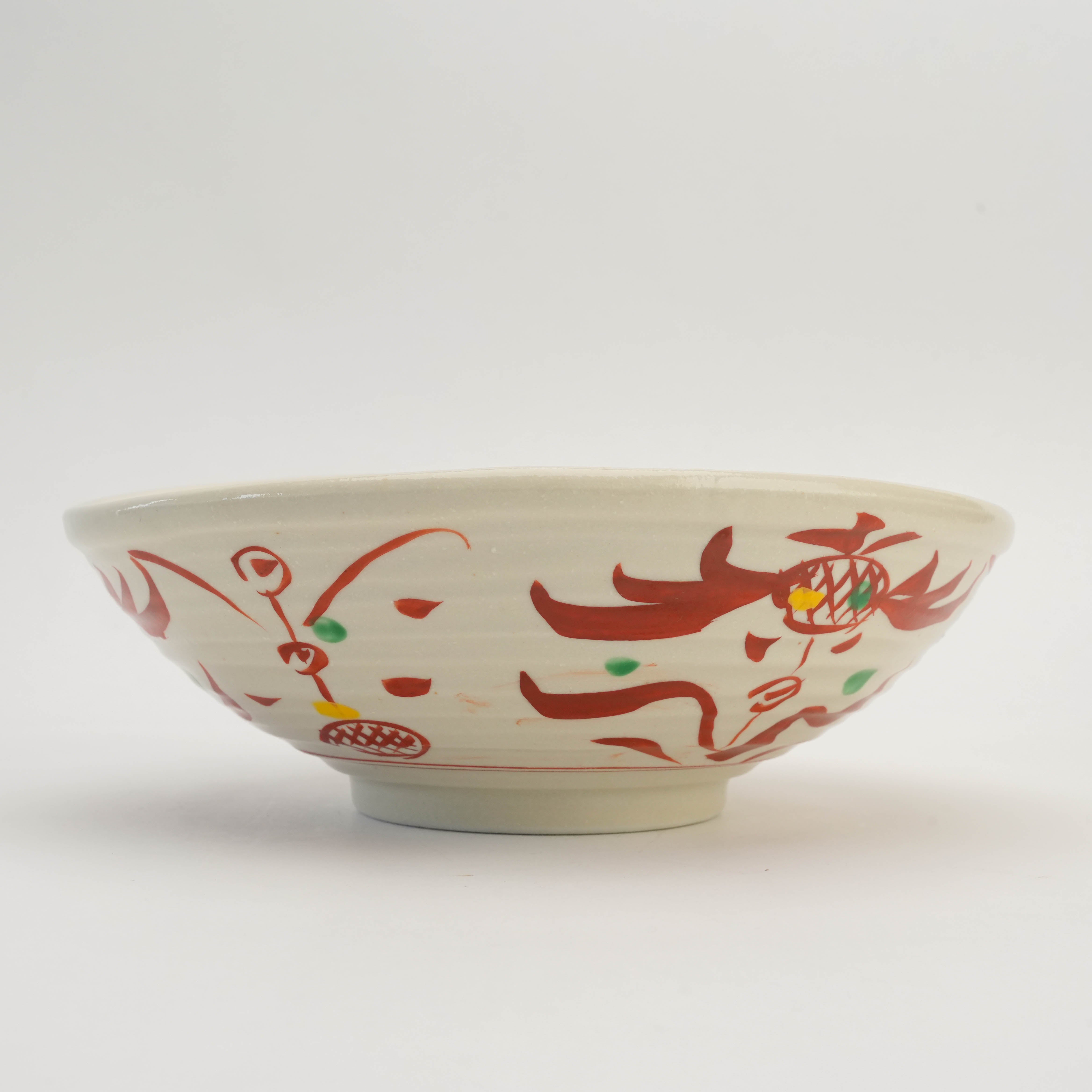 Side view of Mino Ware Kohiki Bowl showcasing its wide twisted shape and intricate red and green akae patterns for elegant tableware use.