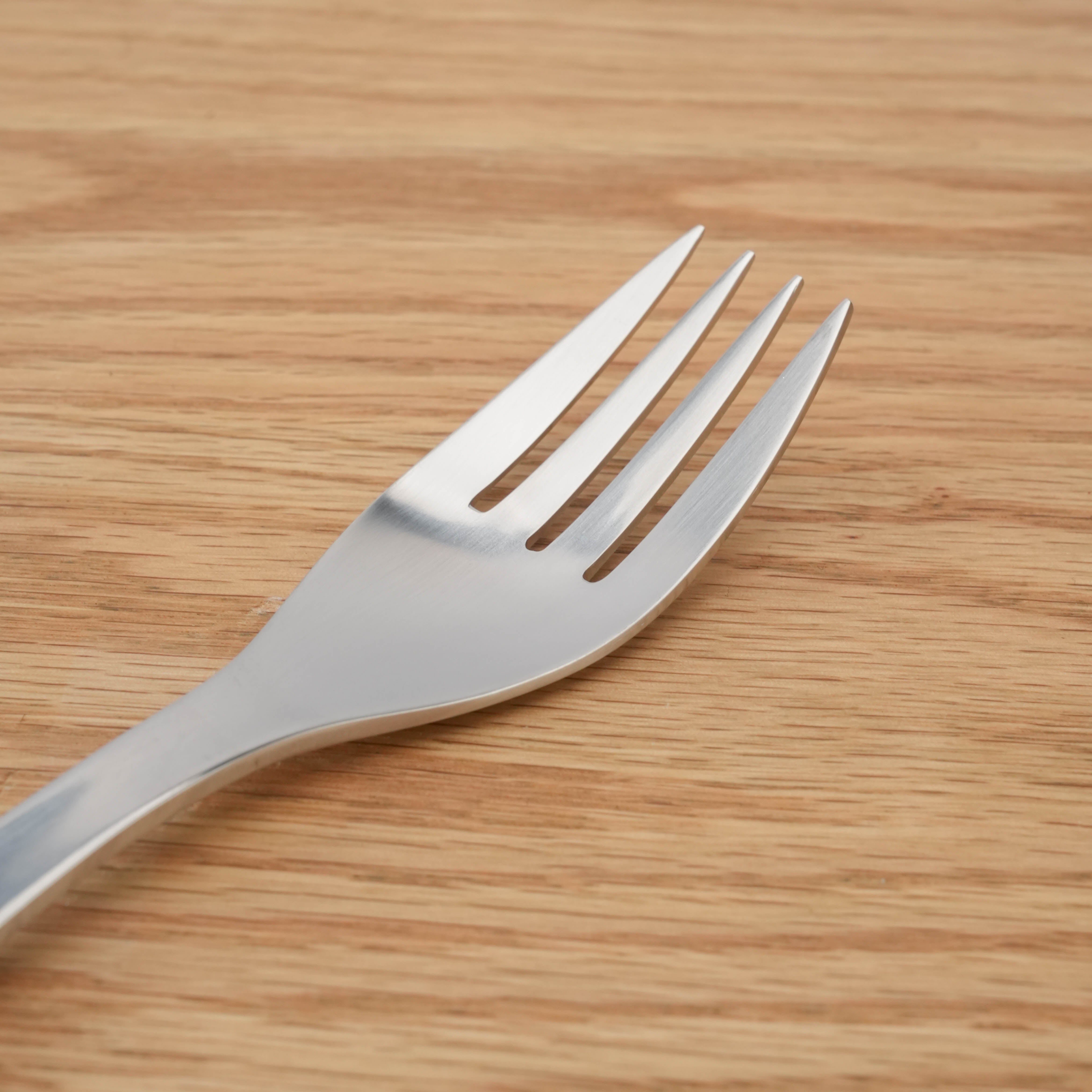 Close-up of Sori Yanagi Stainless Steel Dinner Fork highlighting its smooth finish and ergonomic prong design.