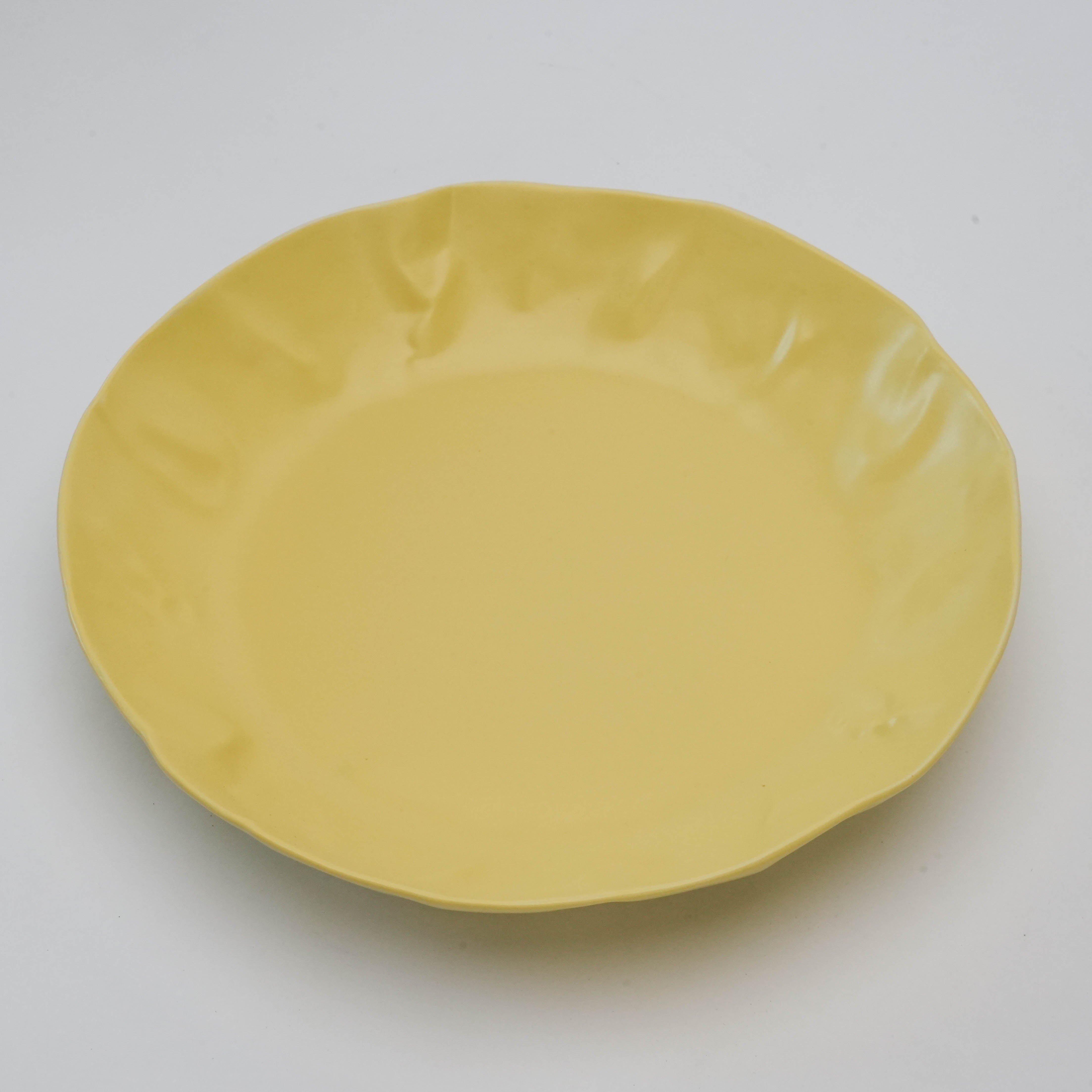 Top view of yellow Hasami Ware Papyrus Curry Dish highlighting its organic, crumpled-edge design ideal for pasta or curry meals.