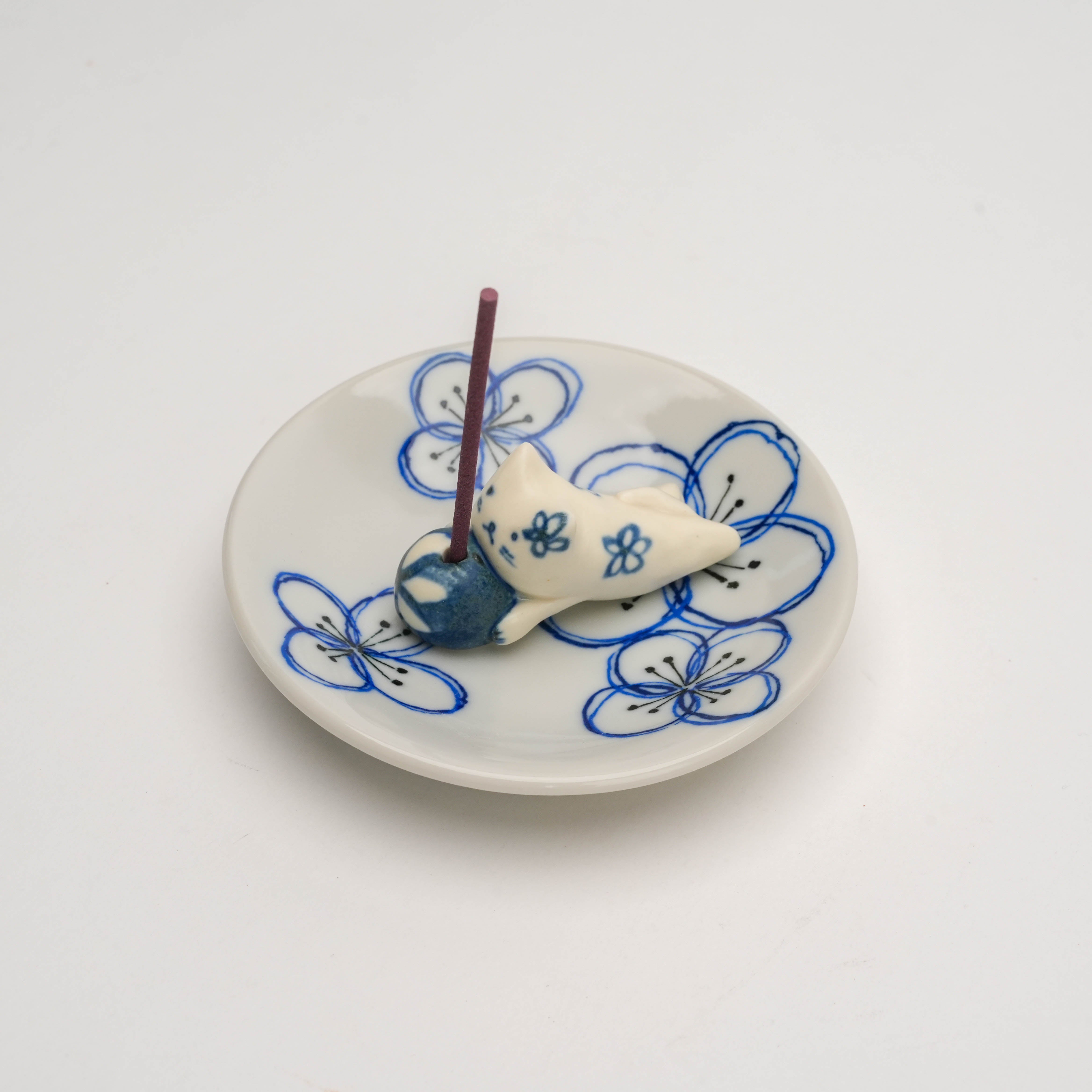 Top view of Dyed Flower Cat Incense Holder with incense stick inserted, showcasing detailed floral artwork and ceramic craftsmanship.