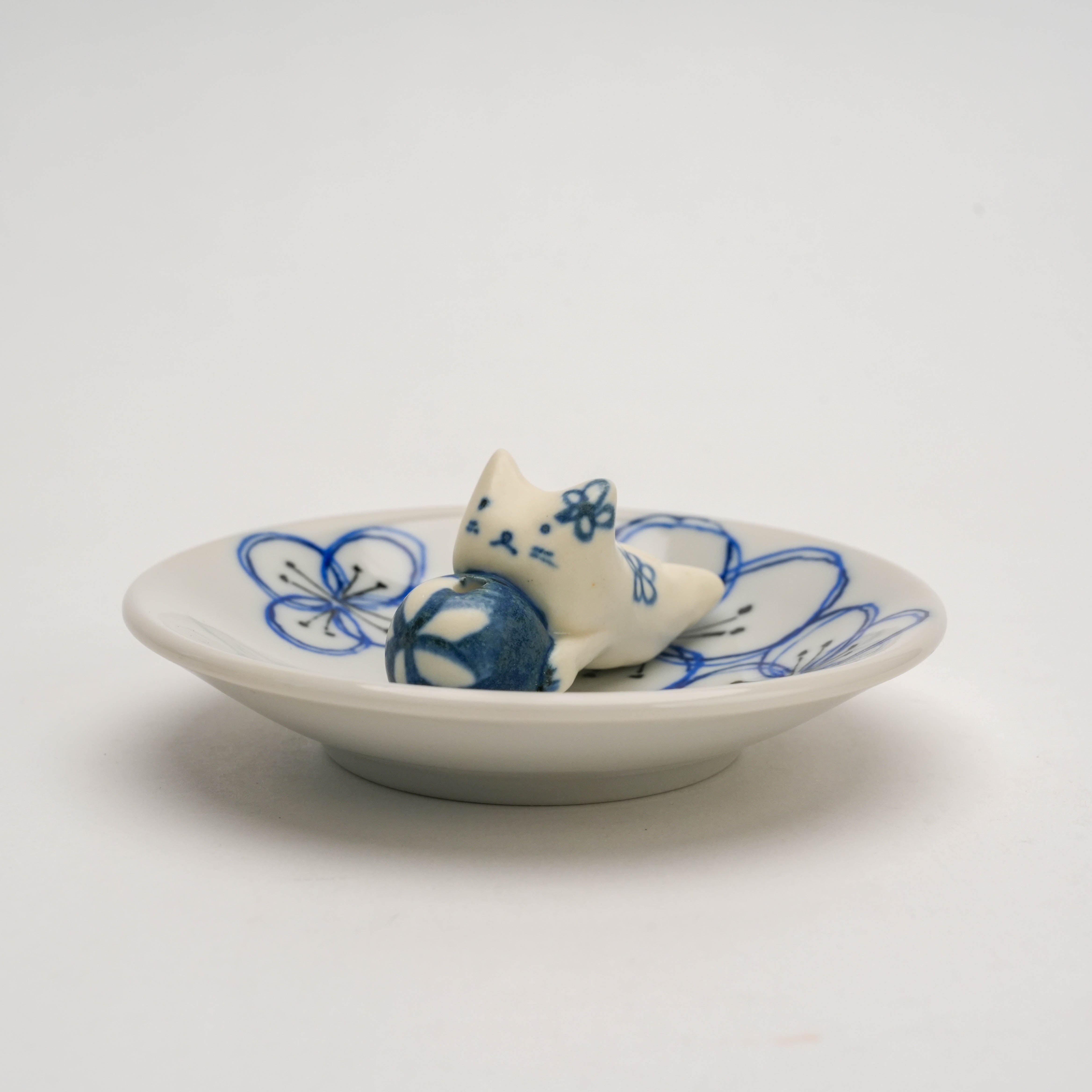 Close-up of Dyed Flower Cat Incense Holder showing hand-painted blue floral designs and ceramic cat resting on the dish.