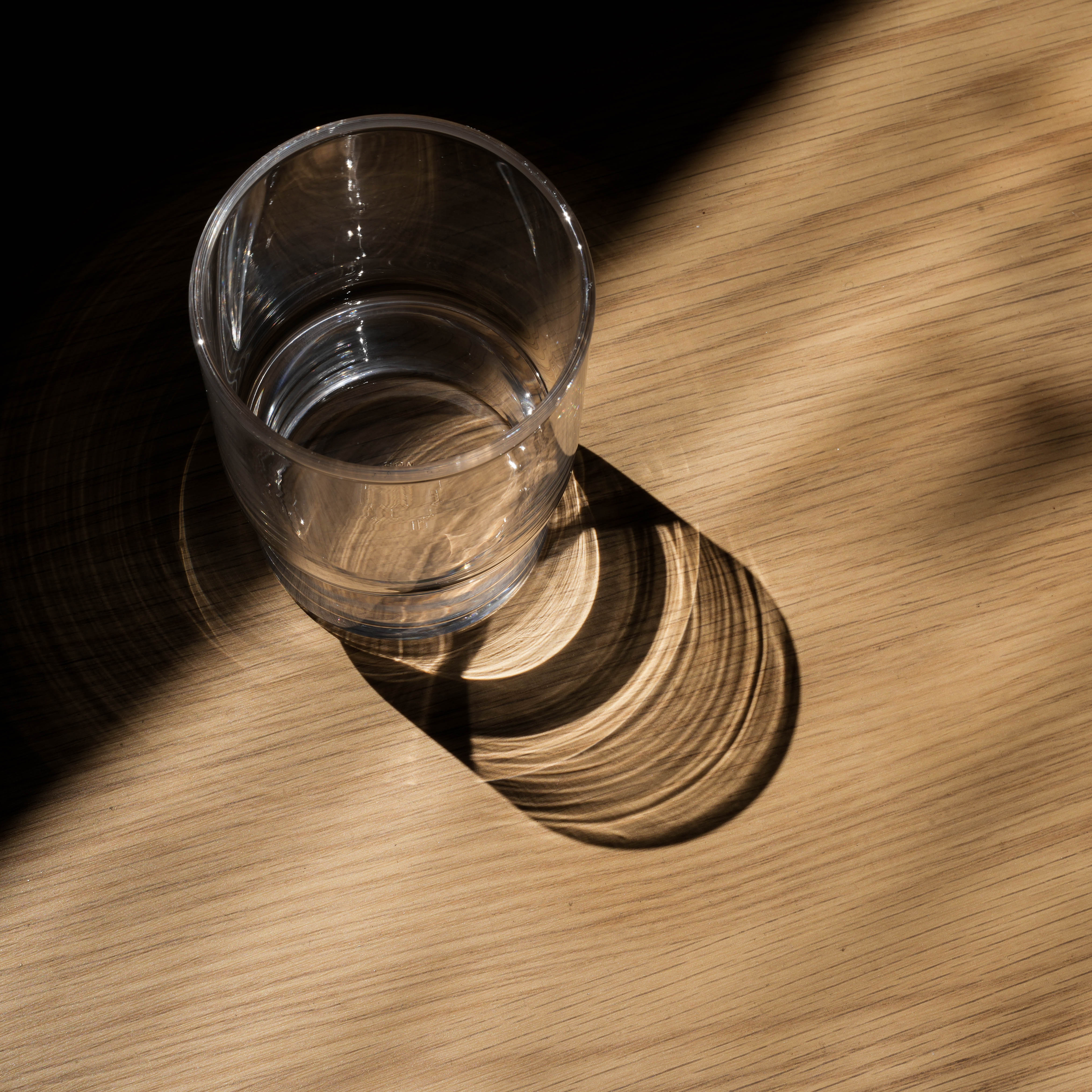 Top view of Toyo-Sasaki Stackable Tumbler casting artistic shadow, highlighting the clarity and craftsmanship of this durable glass tumbler.