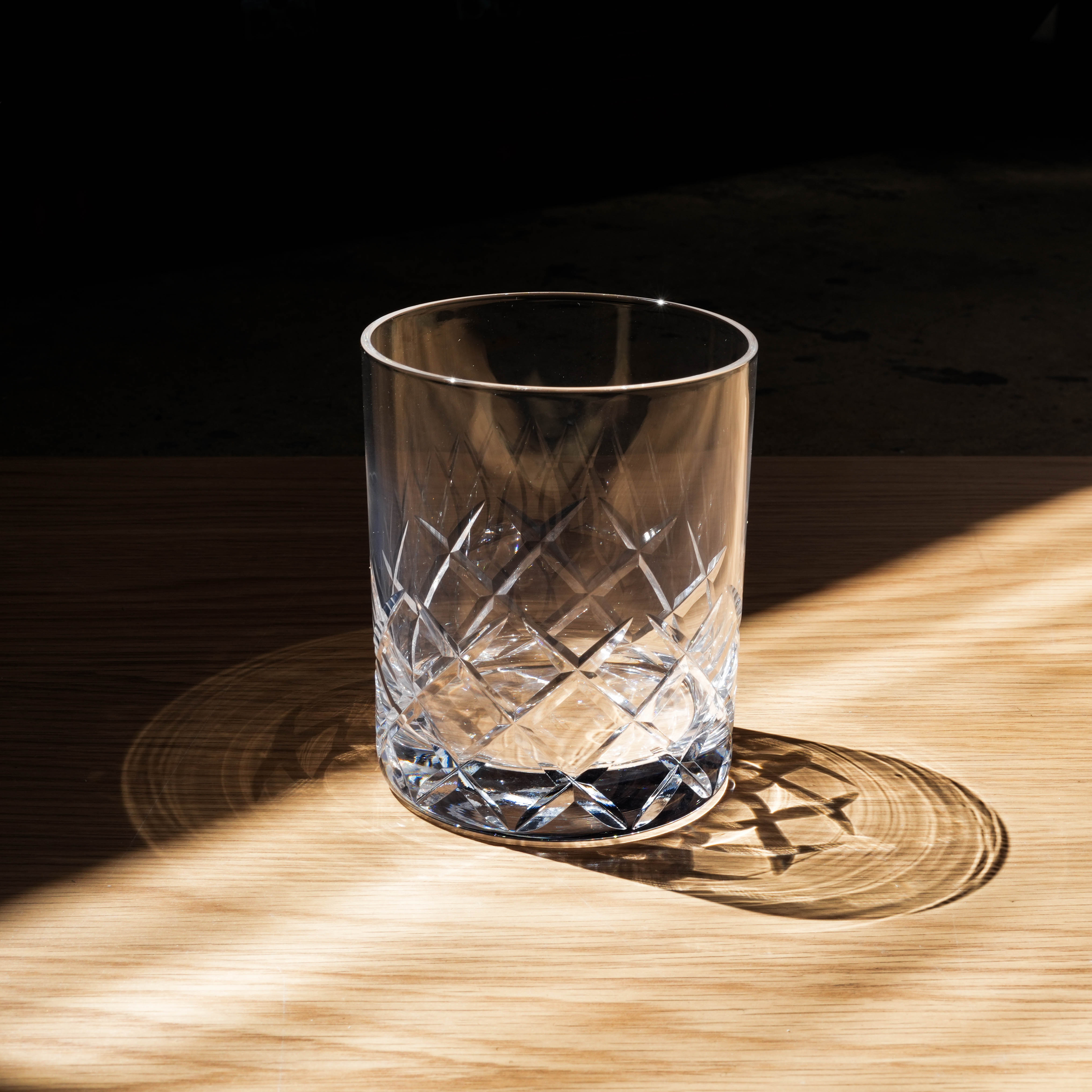 Toyo-Sasaki Yarai Cut Glass - Whiskey Rock Glass | HS Series shown in dramatic lighting on wood surface, highlighting its intricate cut design.