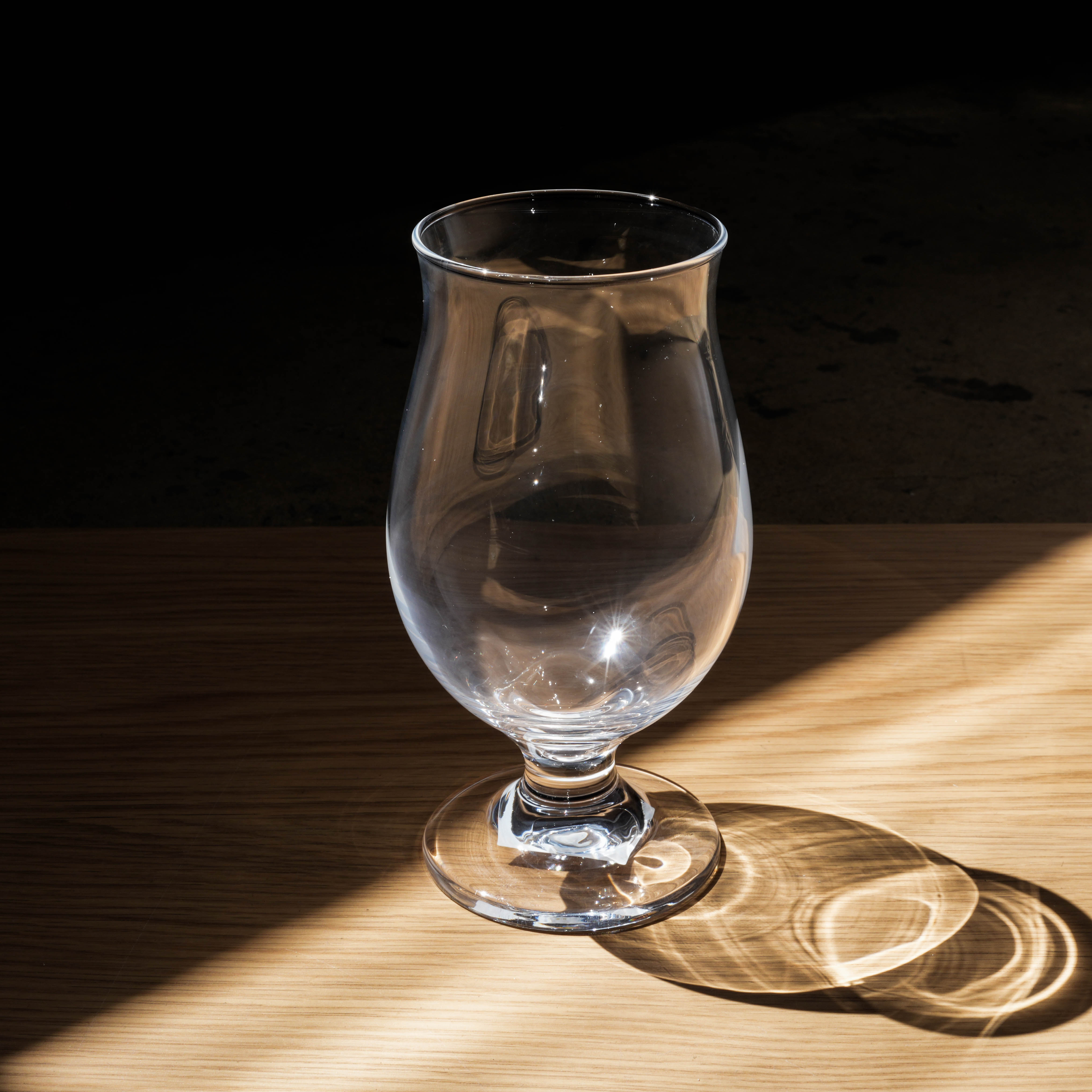 Close-up of Toyo-Sasaki Tulip Beer Glass under natural light, highlighting its shape for optimal beer aroma and flavor.