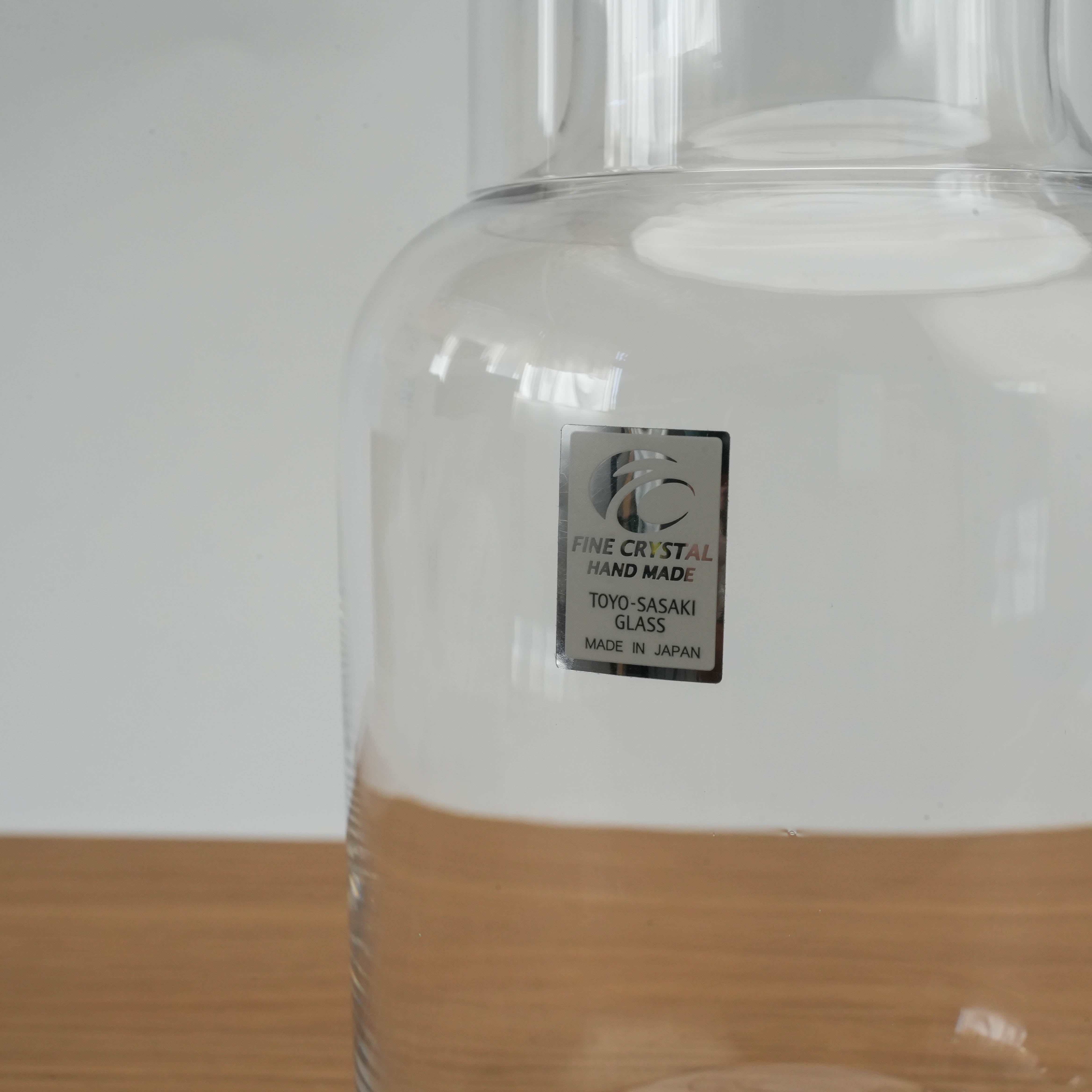 Detail of Toyo-Sasaki Night Carafe label showing 'Fine Crystal Handmade' and 'Made in Japan' on the clear glass surface.