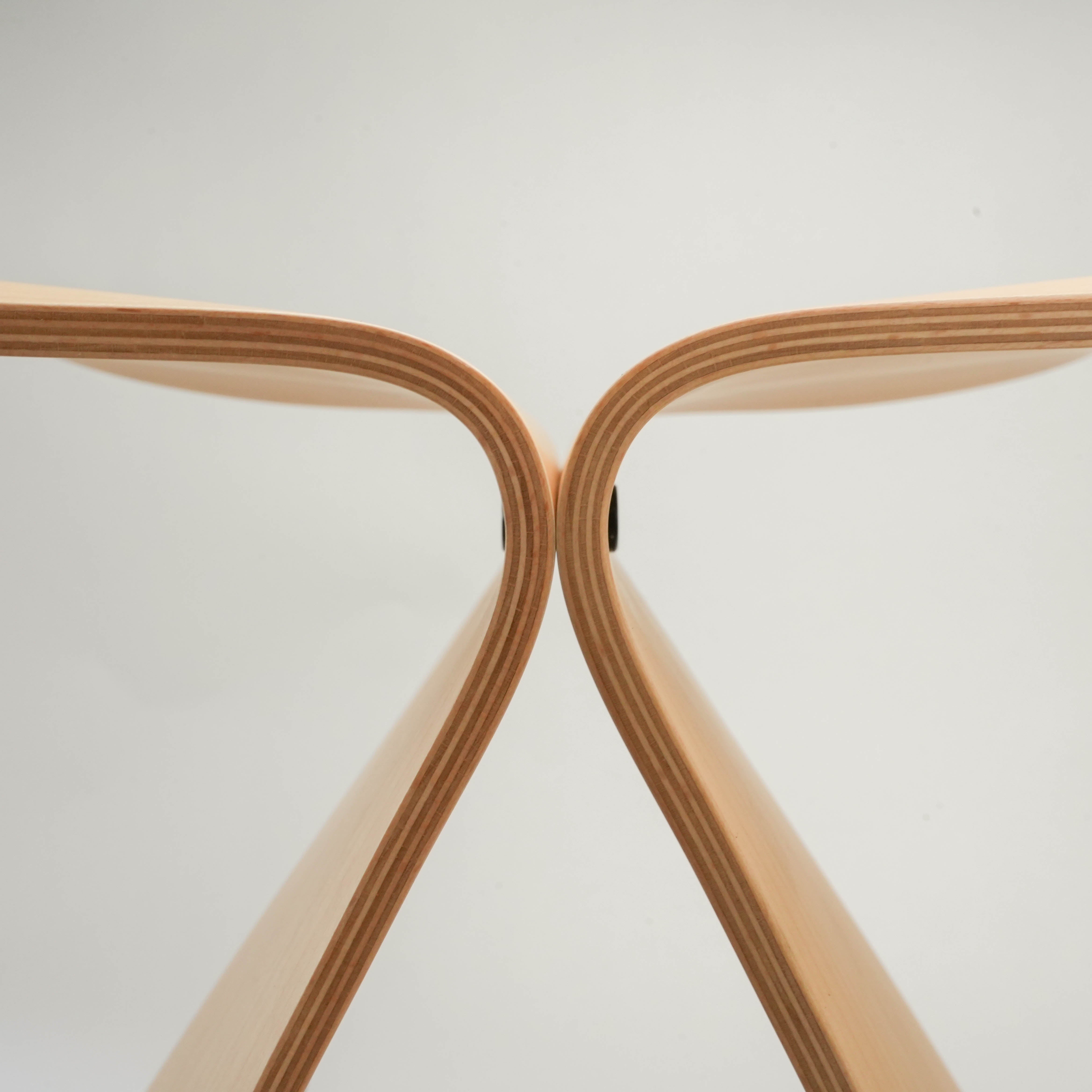 Top-down view of Butterfly Stool by Sori Yanagi, emphasizing the seamless V-shaped curve of the molded plywood seat.