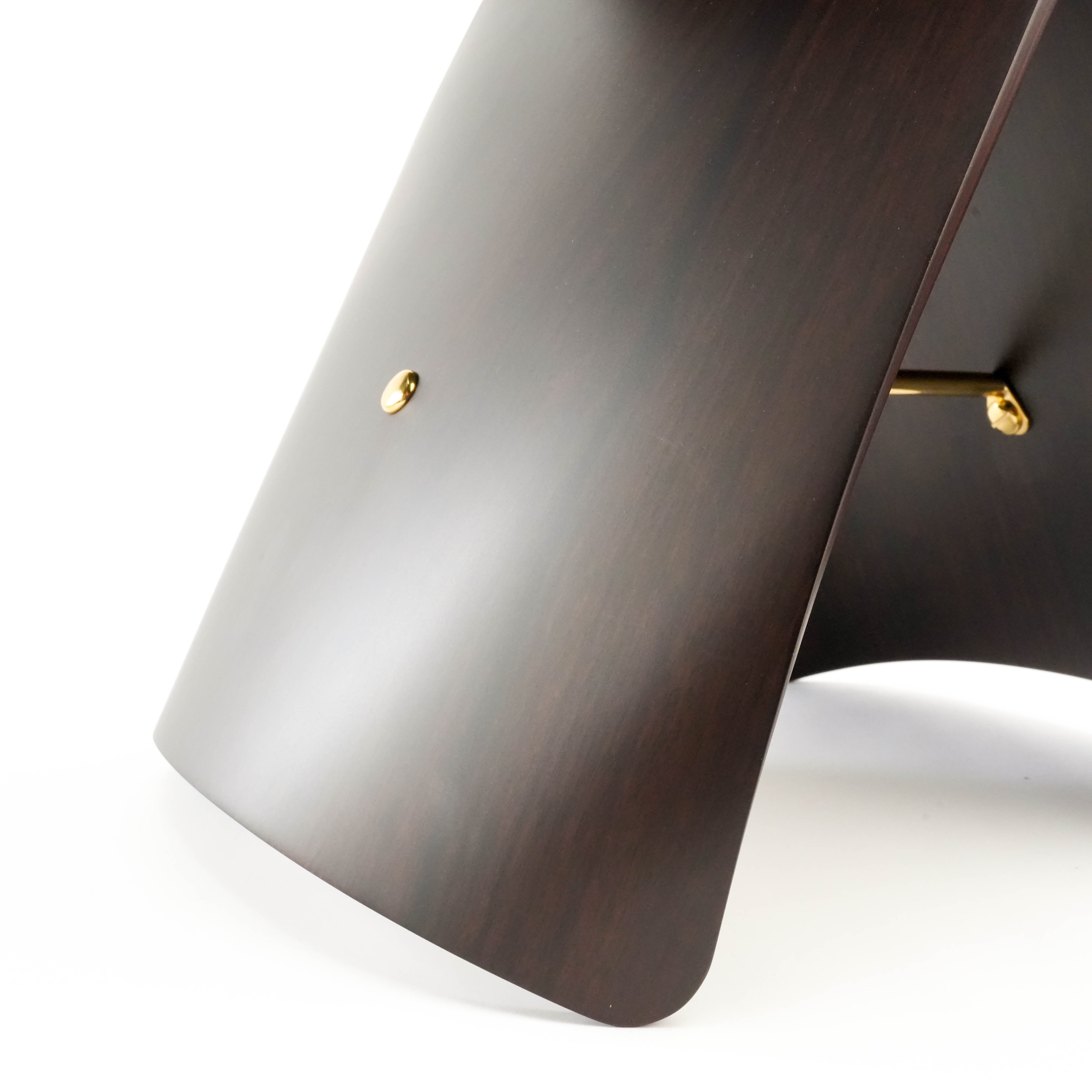 Close-up of dark wood Butterfly Stool leg, highlighting the smooth finish and gold hardware for a refined aesthetic.