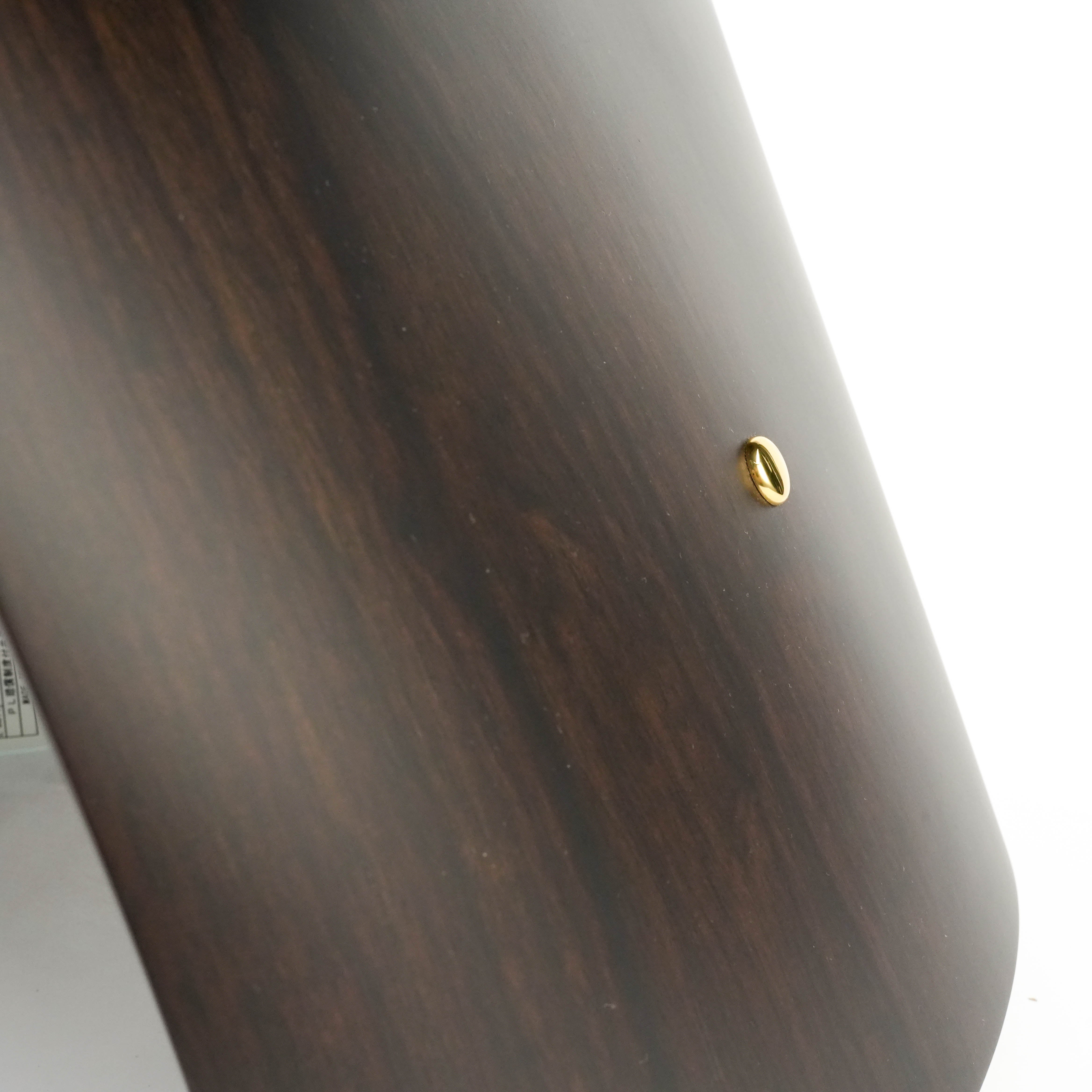 Detail of dark wood grain and brass screw on the Butterfly Stool, reflecting high-quality materials and design integrity.