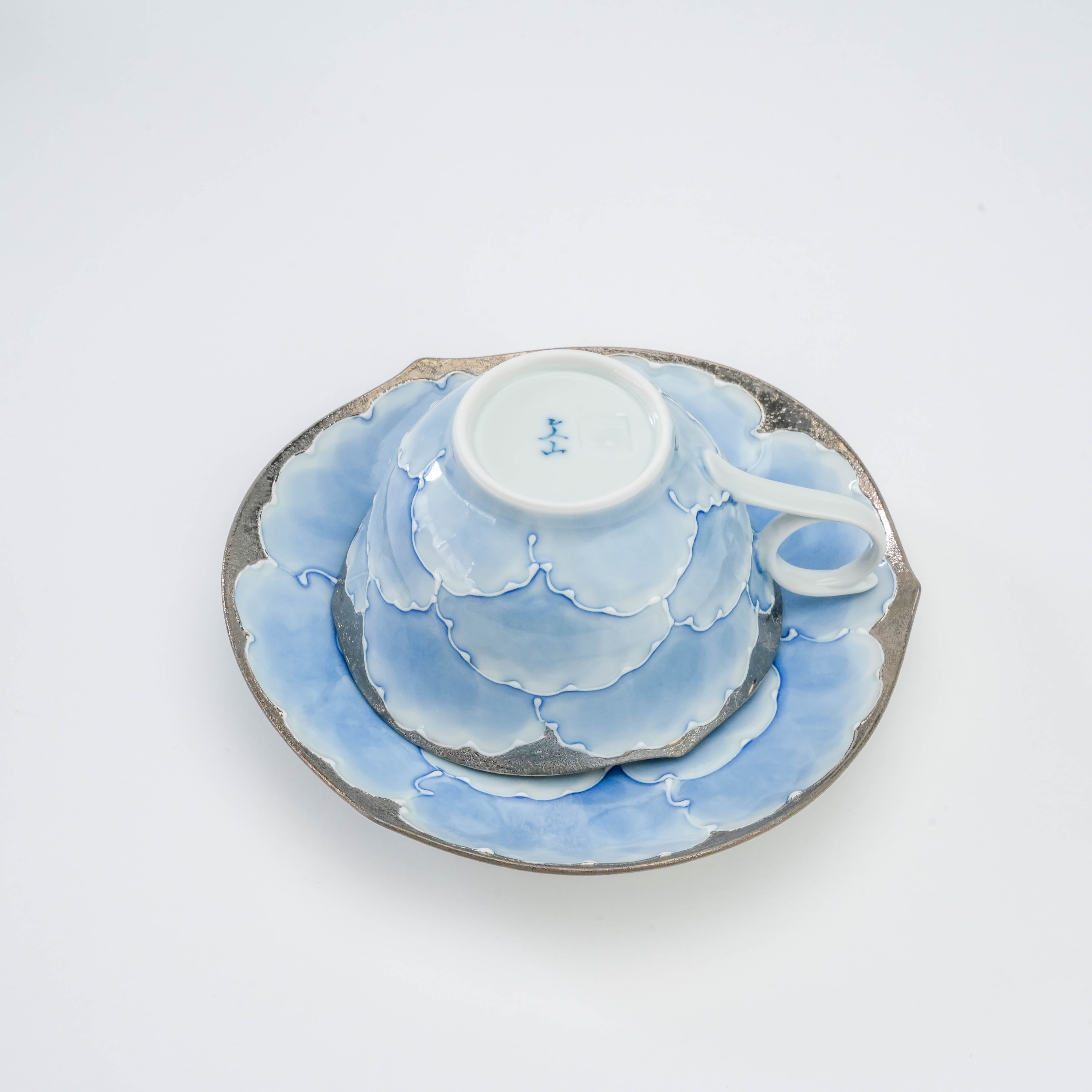 Bottom view of the Arita Ware Bunzan Kiln Cup & Saucer set, highlighting the kiln mark and seamless floral design across cup and saucer.