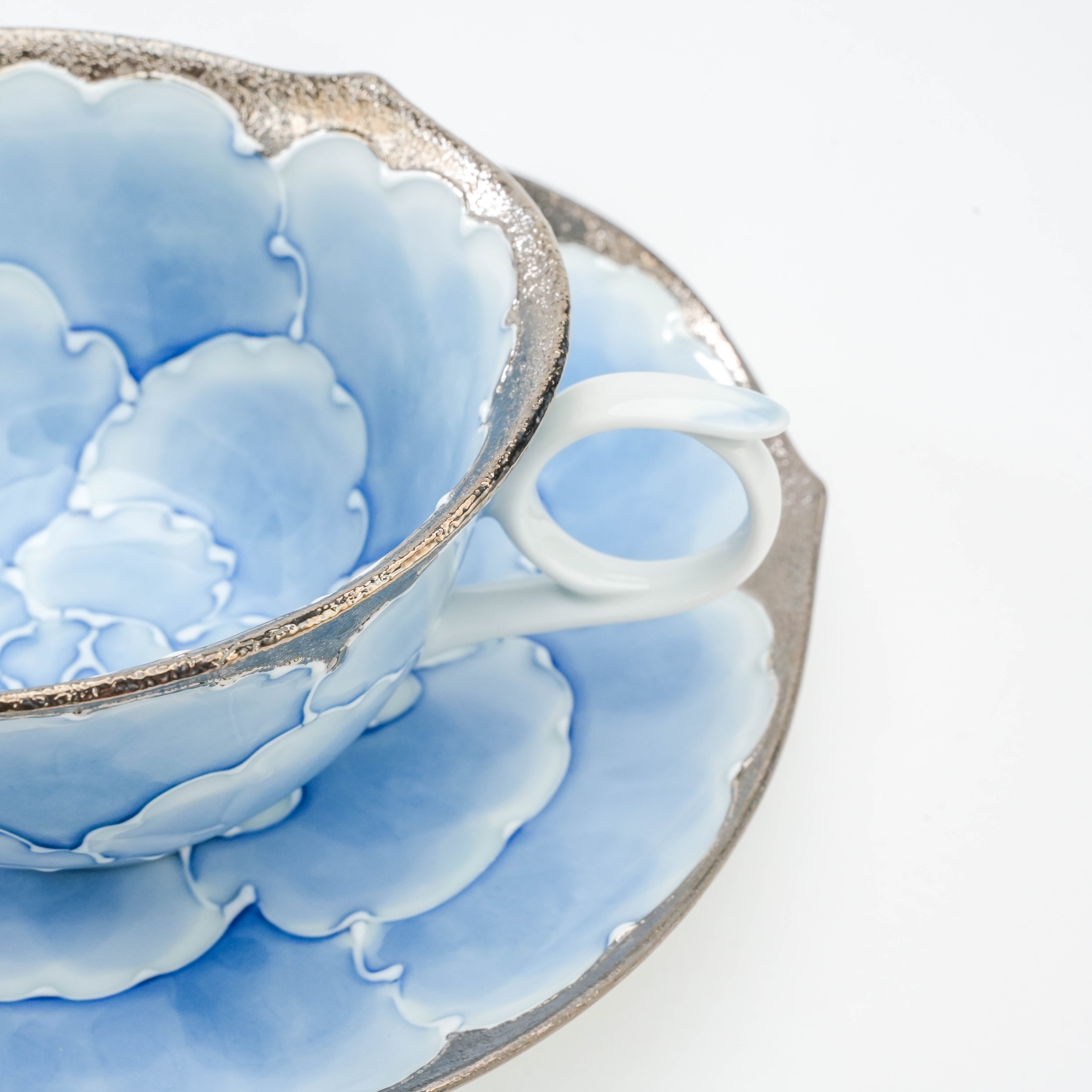 Detailed handle and rim of the Bunzan Kiln Peony Cup, showing the elegant silver trim and blue petal design in fine Arita porcelain.