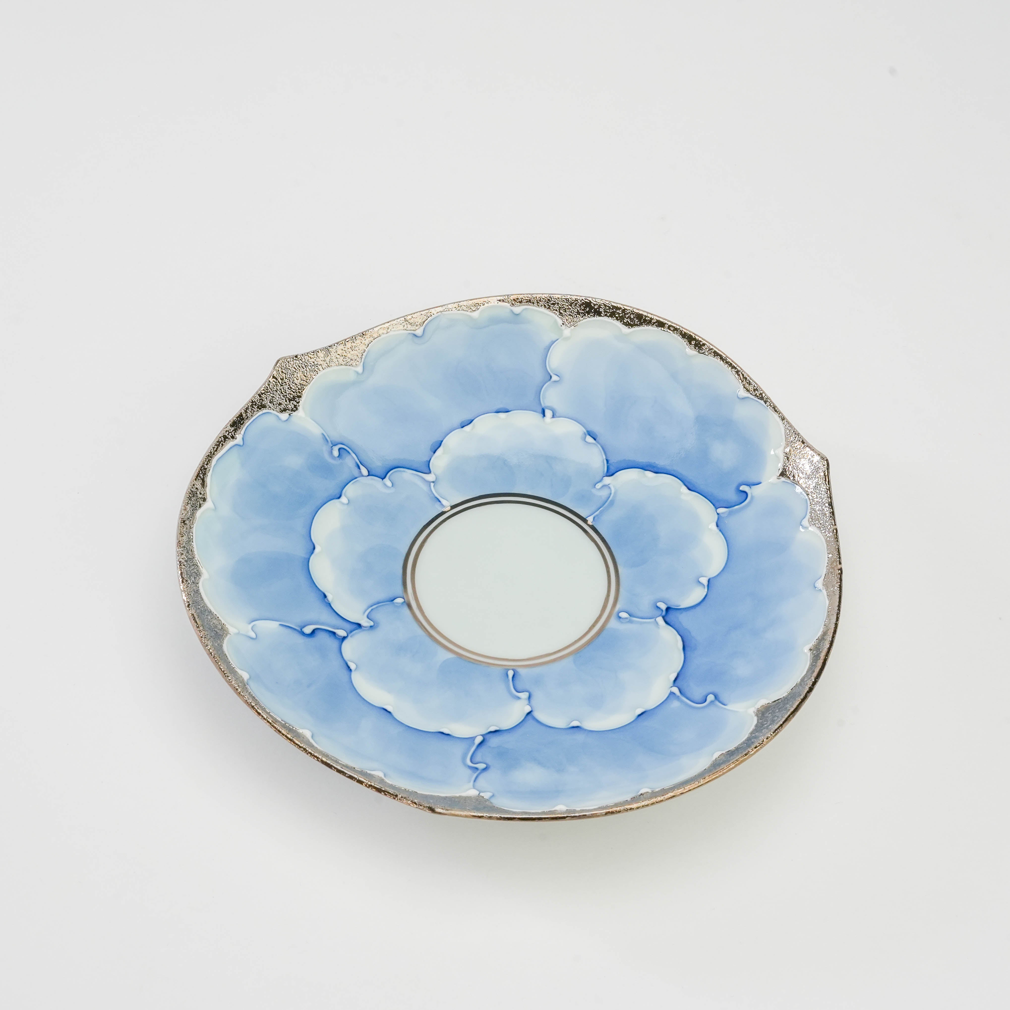 Close-up of Bunzan Kiln Arita Peony Saucer featuring a full bloom blue peony pattern with silver accents, perfect for luxury drinkware collections.
