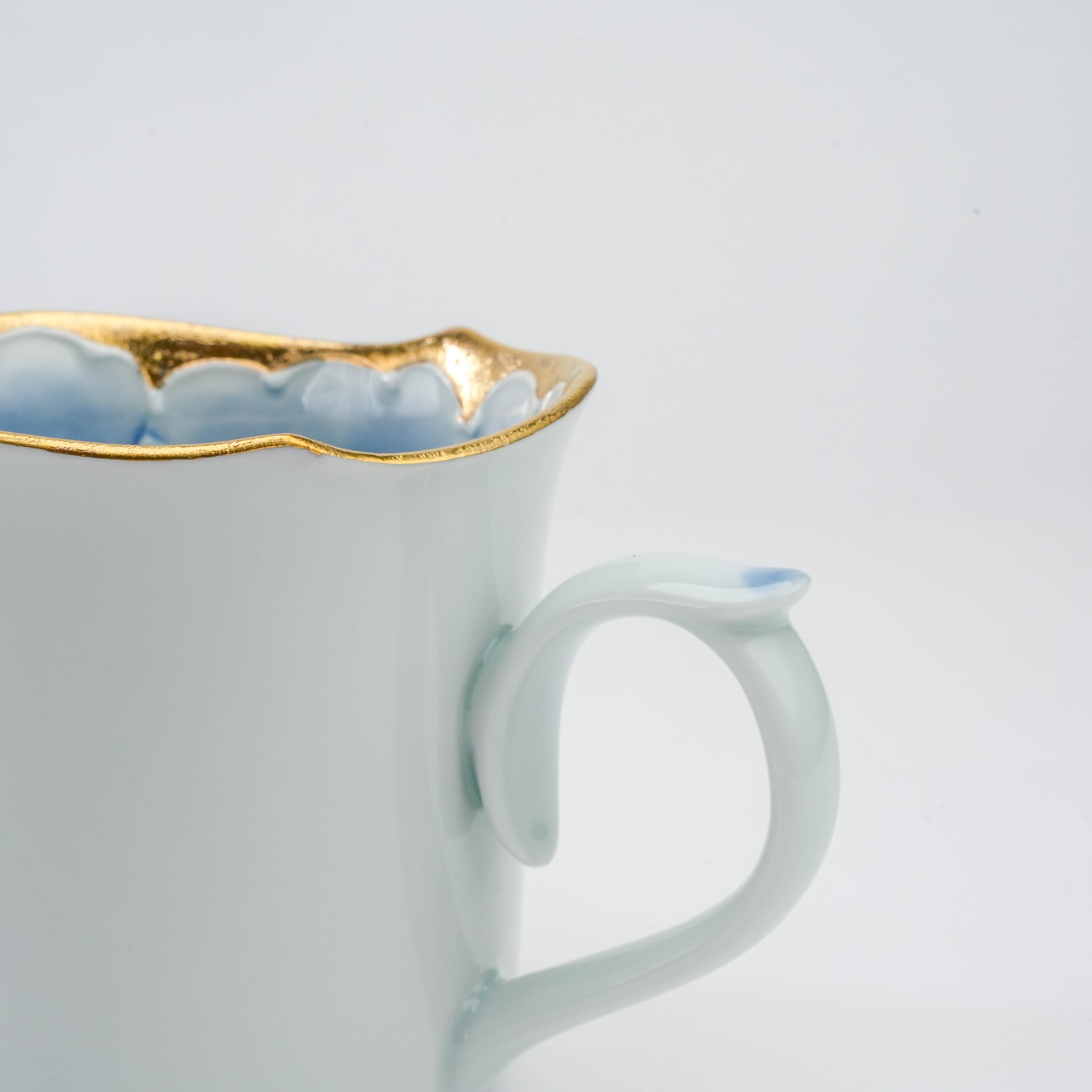 Side handle detail of Arita Ware Peony Mug with soft blue glaze and gold-accented rim, blending elegance and functionality in drinkware.