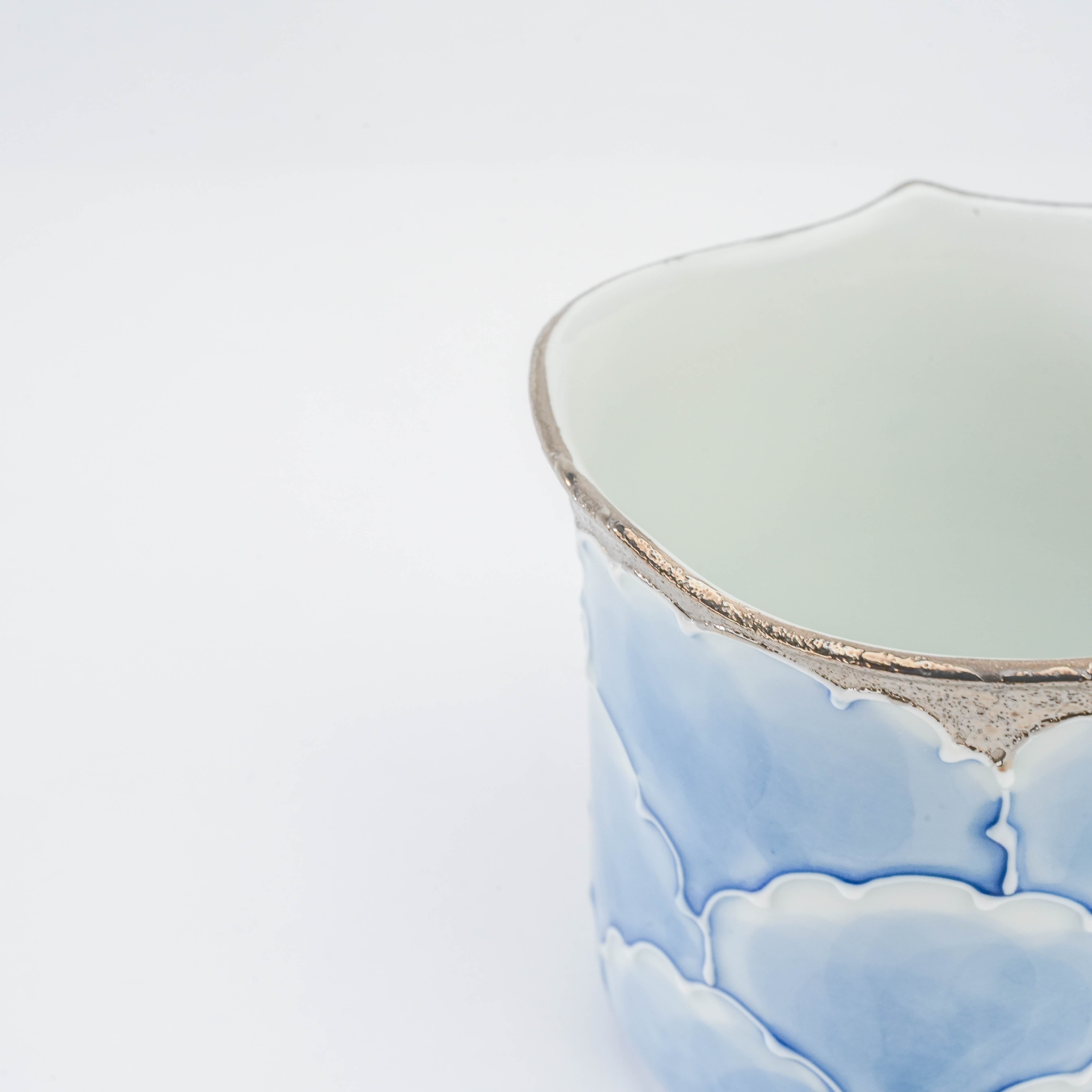 Detail view of the Bunzan Kiln Peony Mug's silver-rimmed edge and soft blue floral glaze, showcasing Arita porcelain craftsmanship.