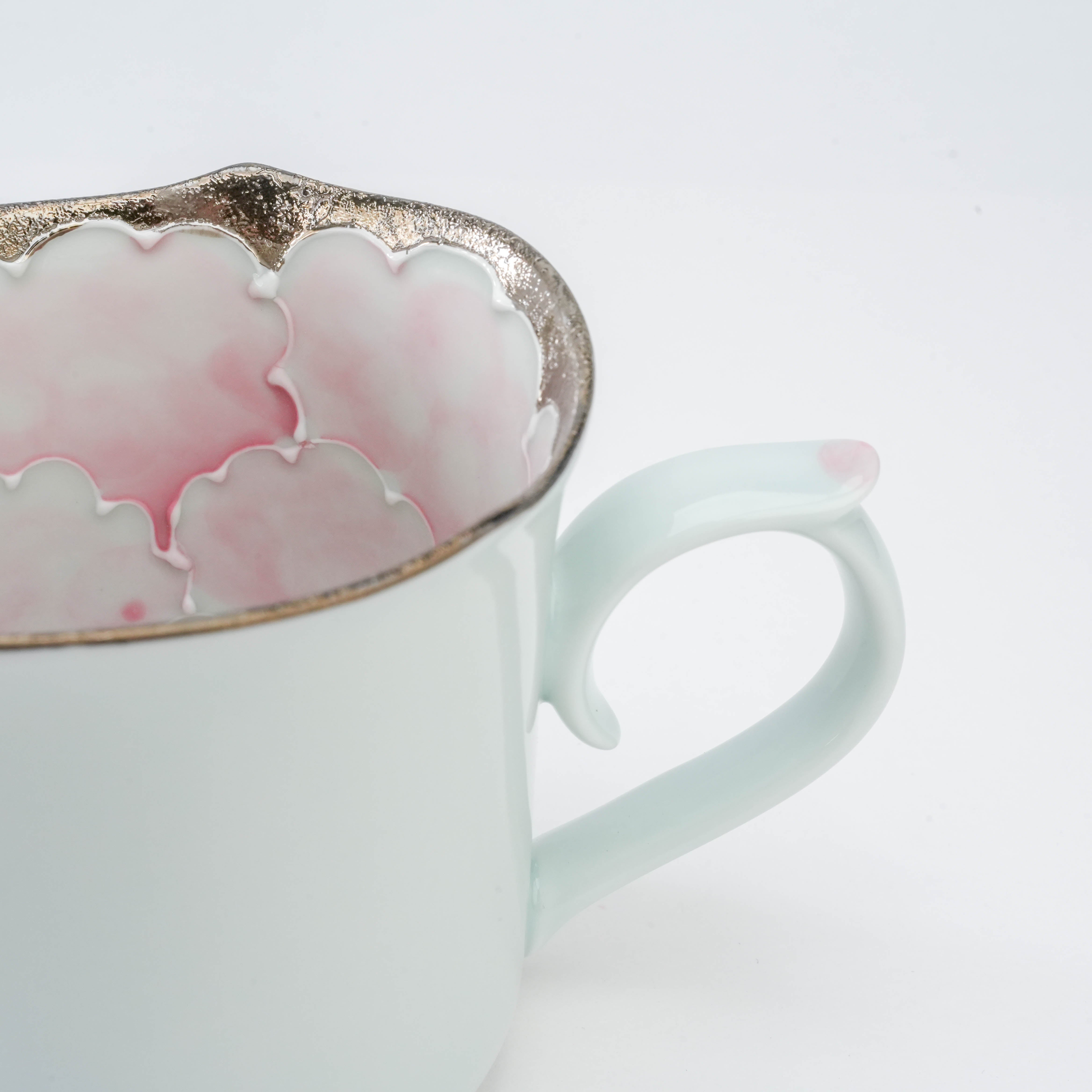 Handle detail of Arita Peony Mug by Bunzan Kiln with soft pastel pink accent and silver-edged floral interior pattern.