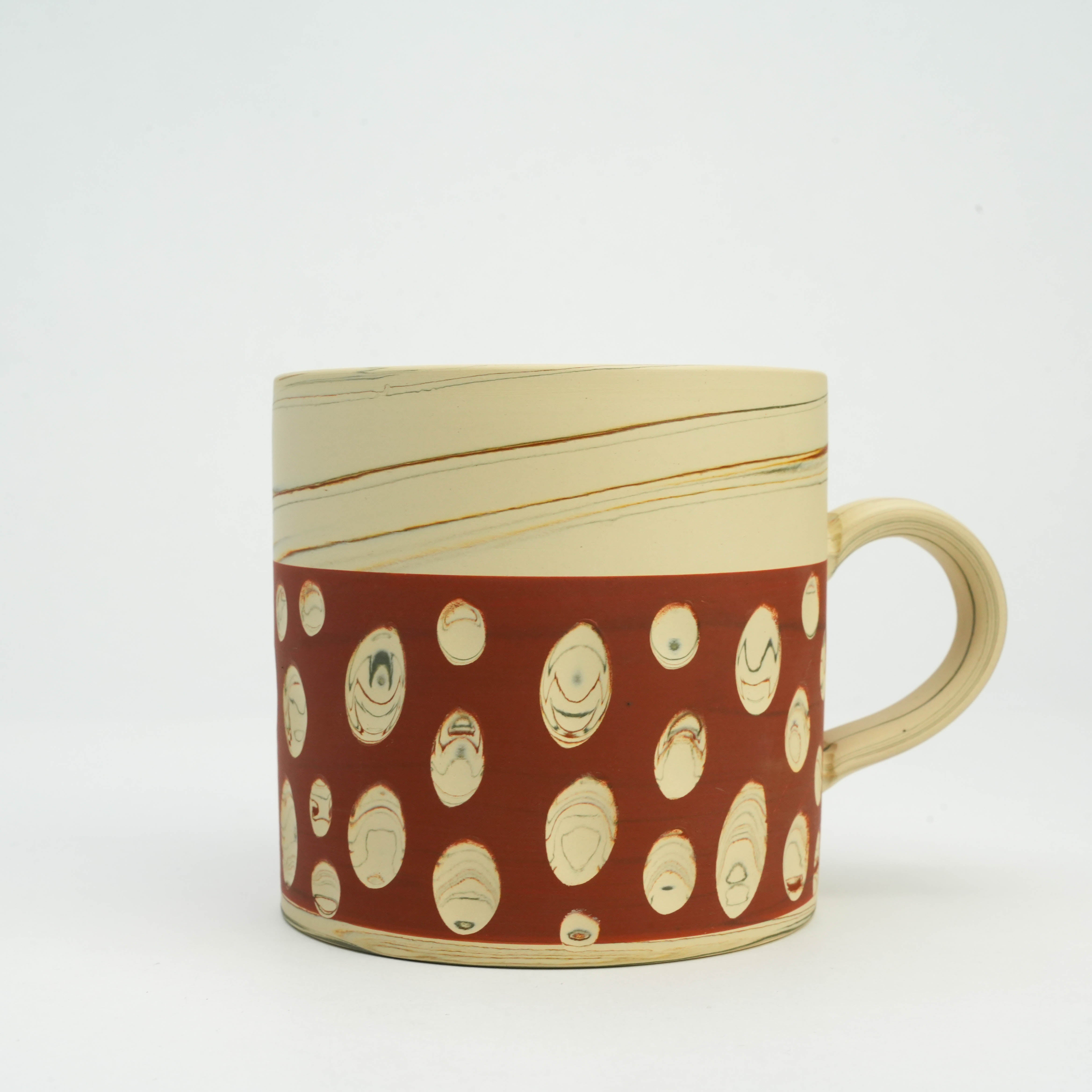 Close-up of red Tokoname pottery mug featuring unique polka dot design, showcasing traditional Japanese craftsmanship for stylish tableware.