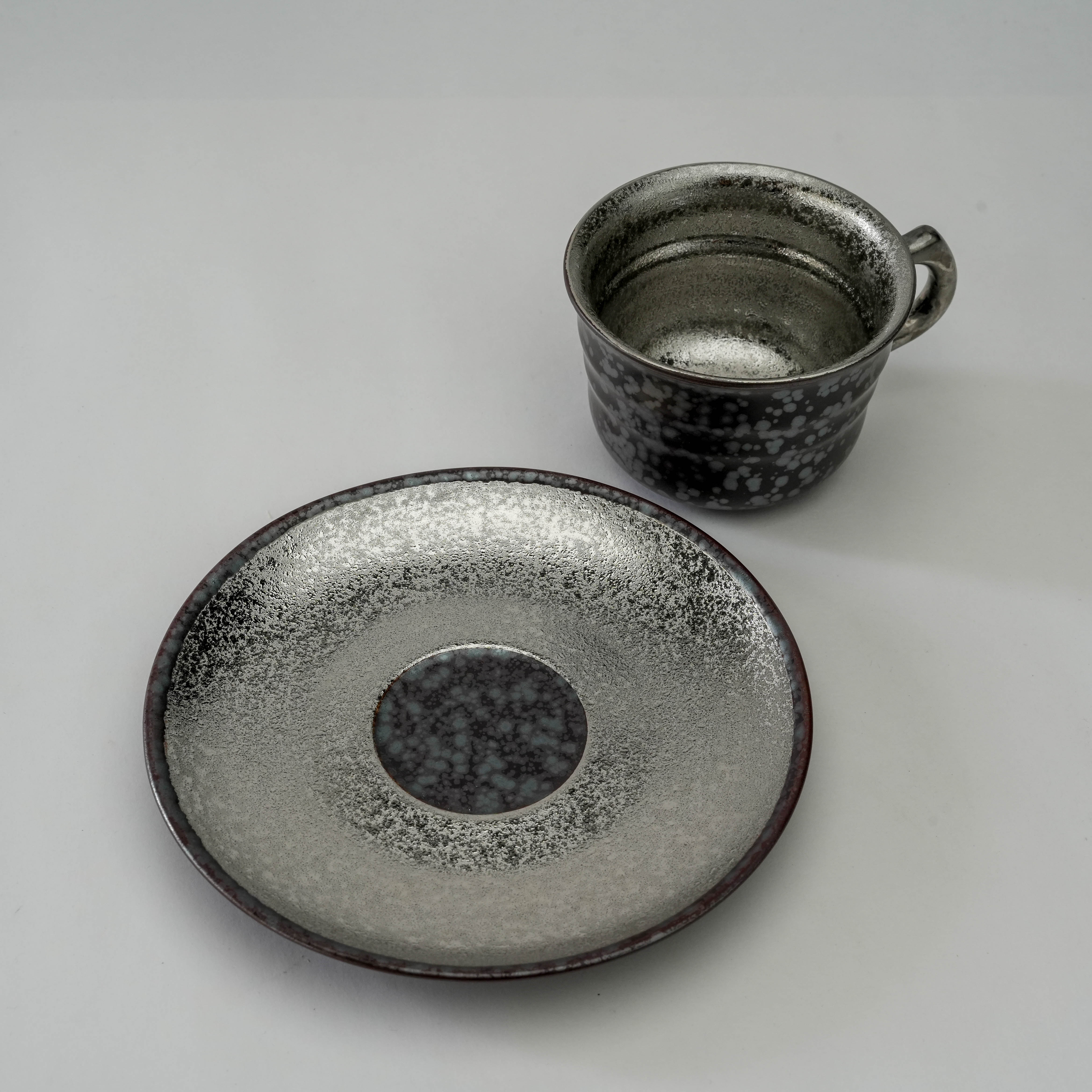 Arita Ware Crystal Glaze Silver Coffee Cup and Saucer separated to display interior and base design. A standout piece in luxury coffee sets.