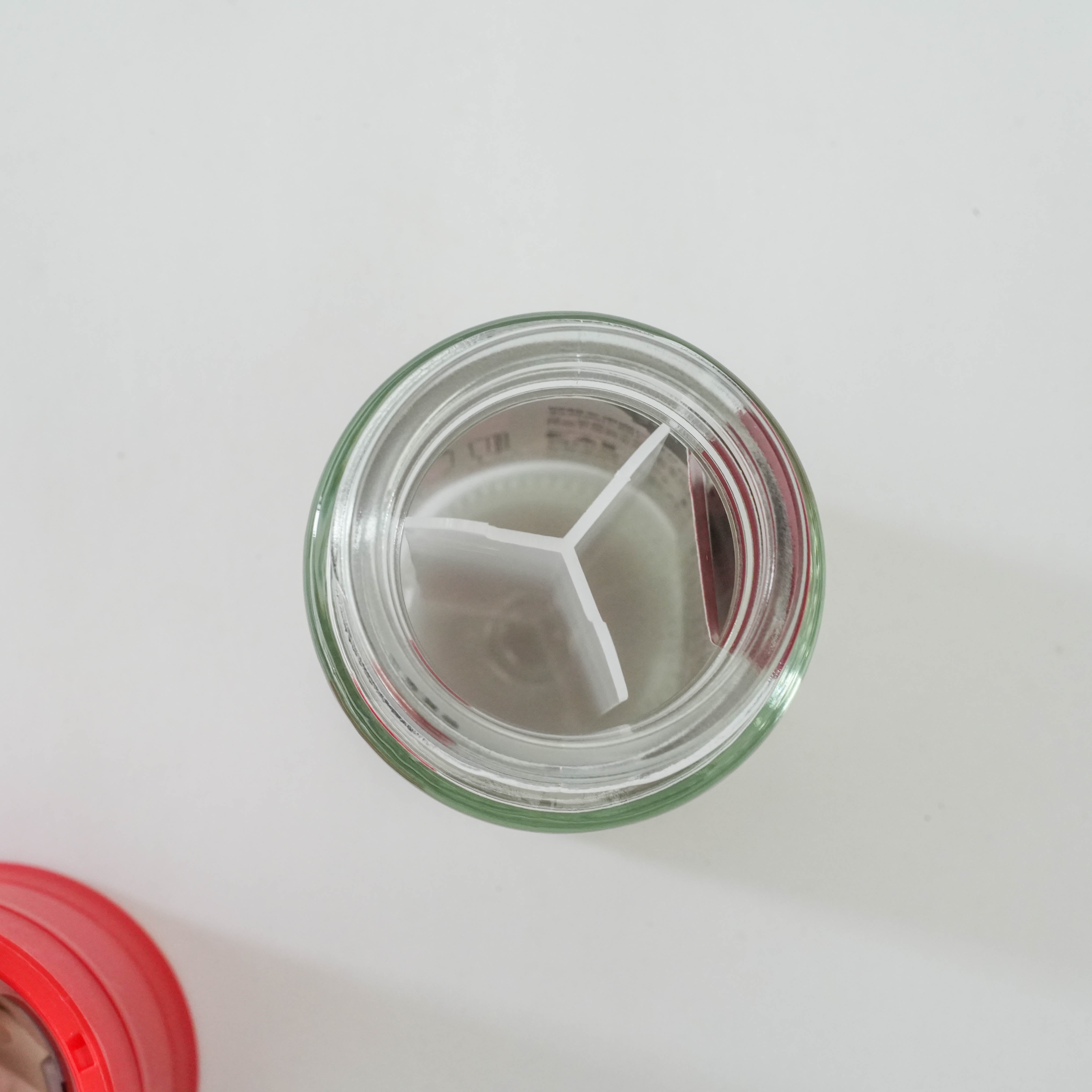 Top view of the Kai Home Ceramic Red Pepper Mill’s spice container with internal divider, ideal for organized spice storage.