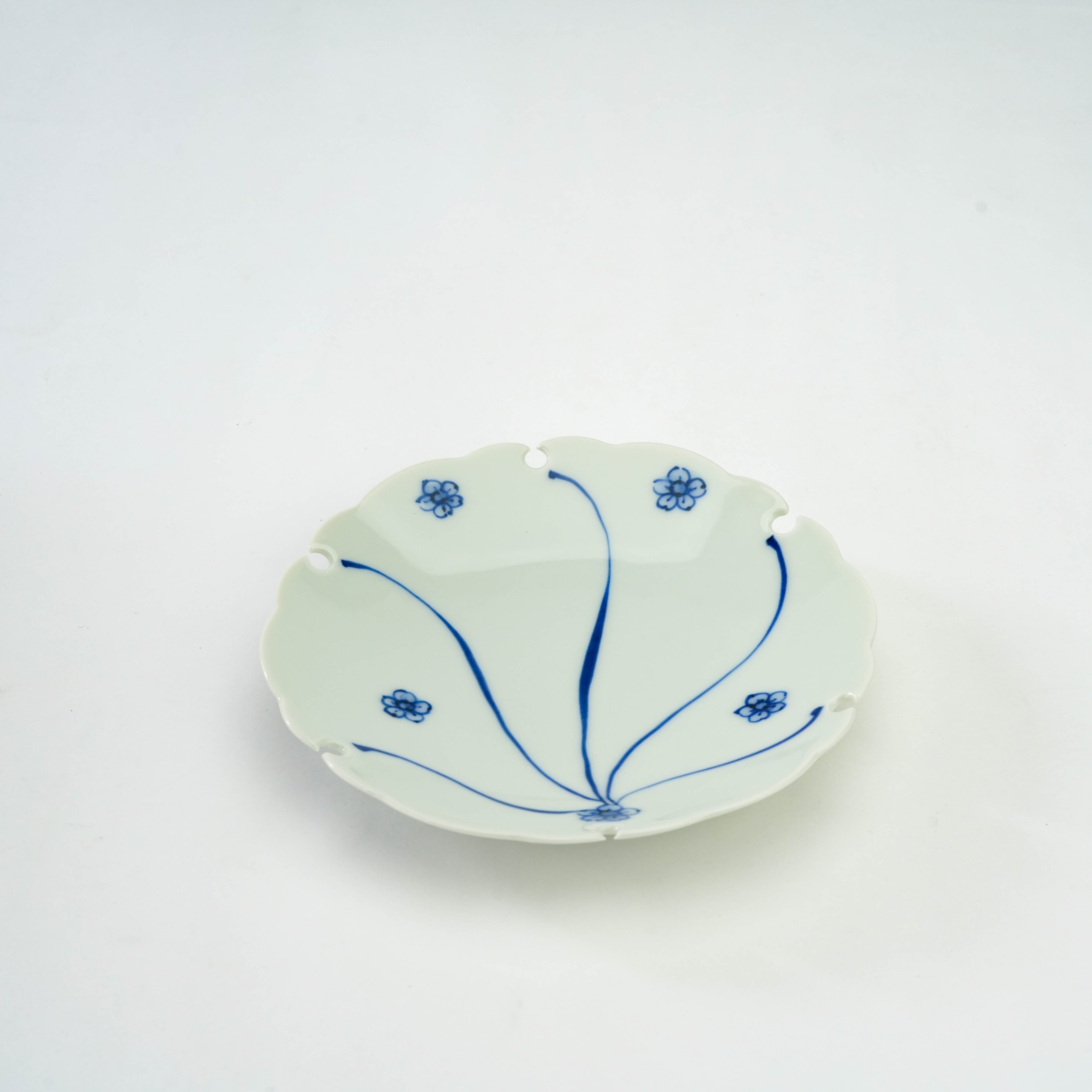 Plum Blossom Plate from Arita Ware featuring smooth white porcelain, delicate floral design, and curved snowflake-like rim for refined dining.