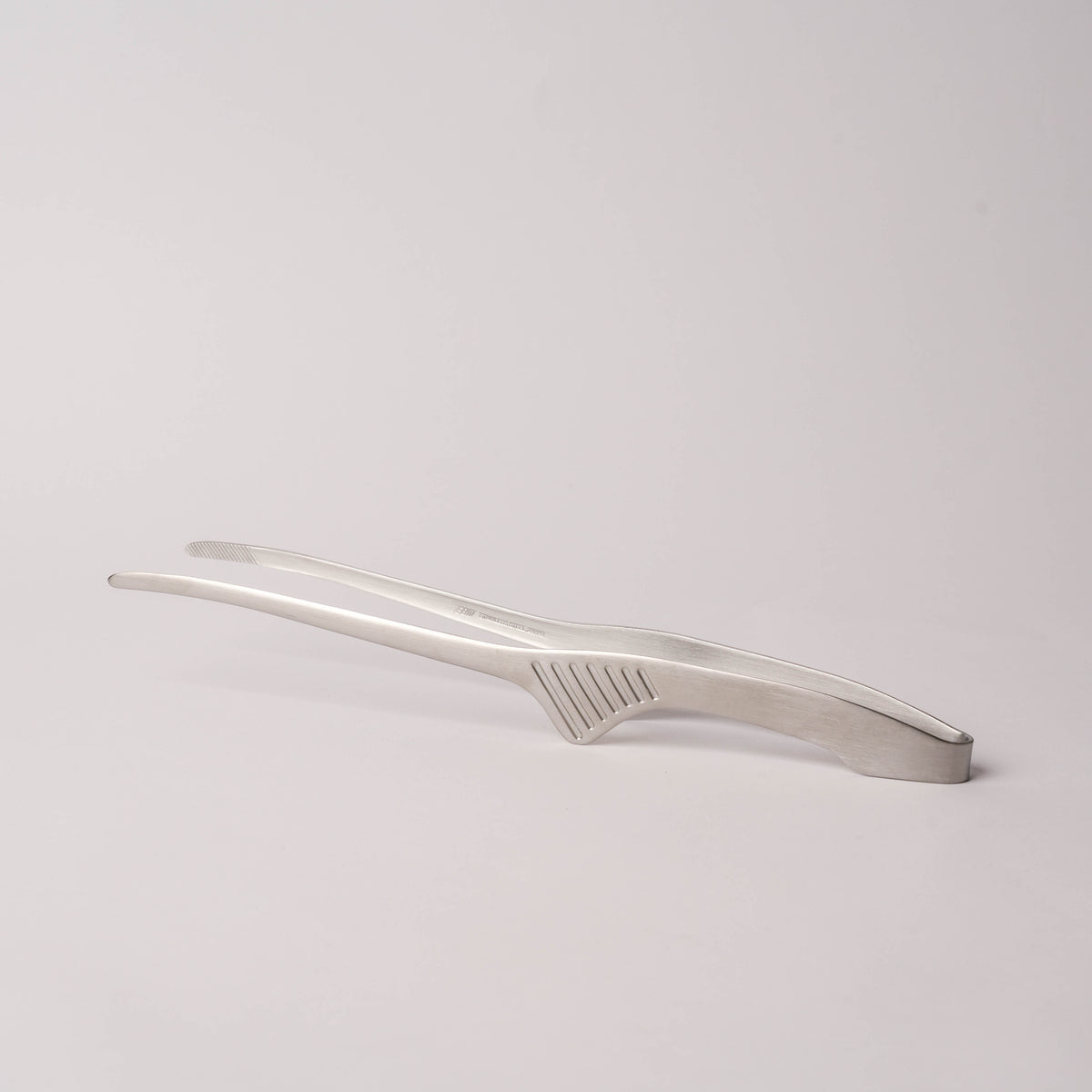 Side view of stainless steel kitchen tongs with textured handle and slim profile, perfect for precise control, SKU: 2052551