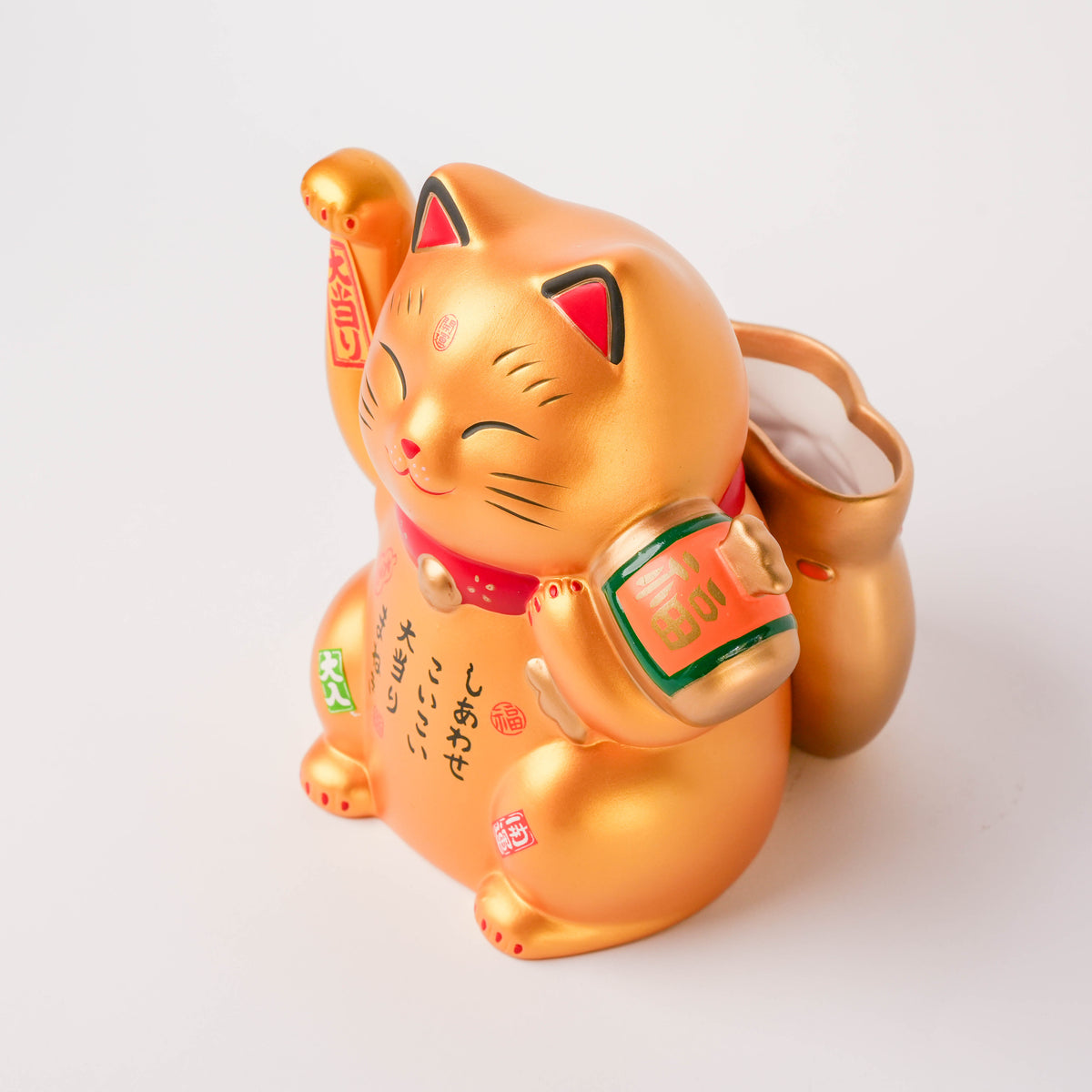 Bottom view of the Lucky Cat's feet with red dots and gold finish, showcasing craftsmanship and detail