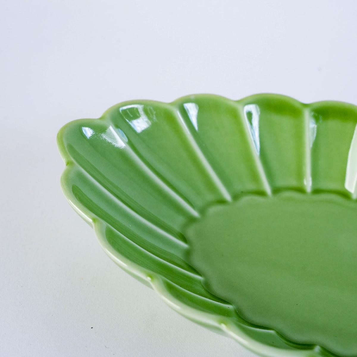 White ceramic oval plate with carved leaf pattern, ideal for serving small dishes or desserts, on a white background