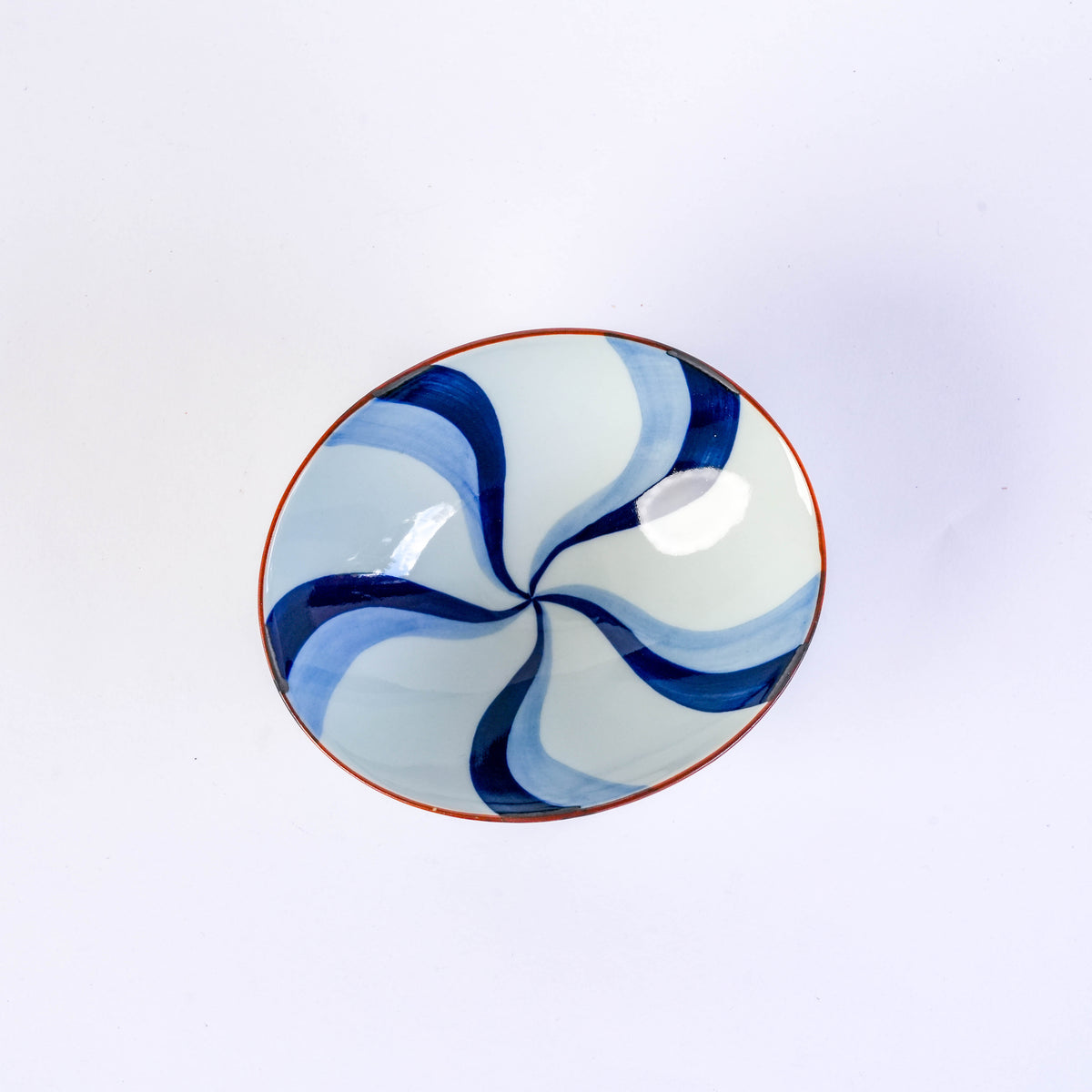Bottom view of the blue and white ceramic bowl with flowing water pattern, showing Japanese characters inside