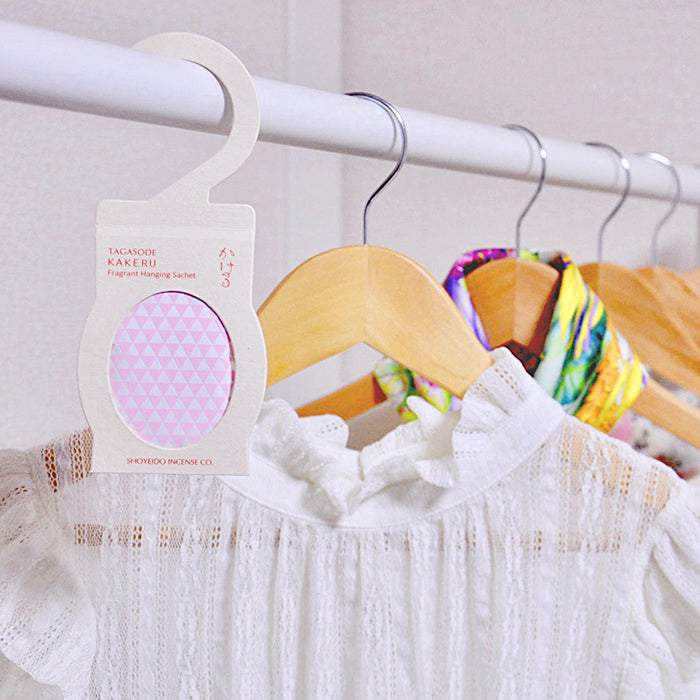 Pink-patterned Shoyeido Sachet hanging among dresses, infusing closets with a subtle lavender and sandalwood aroma.
