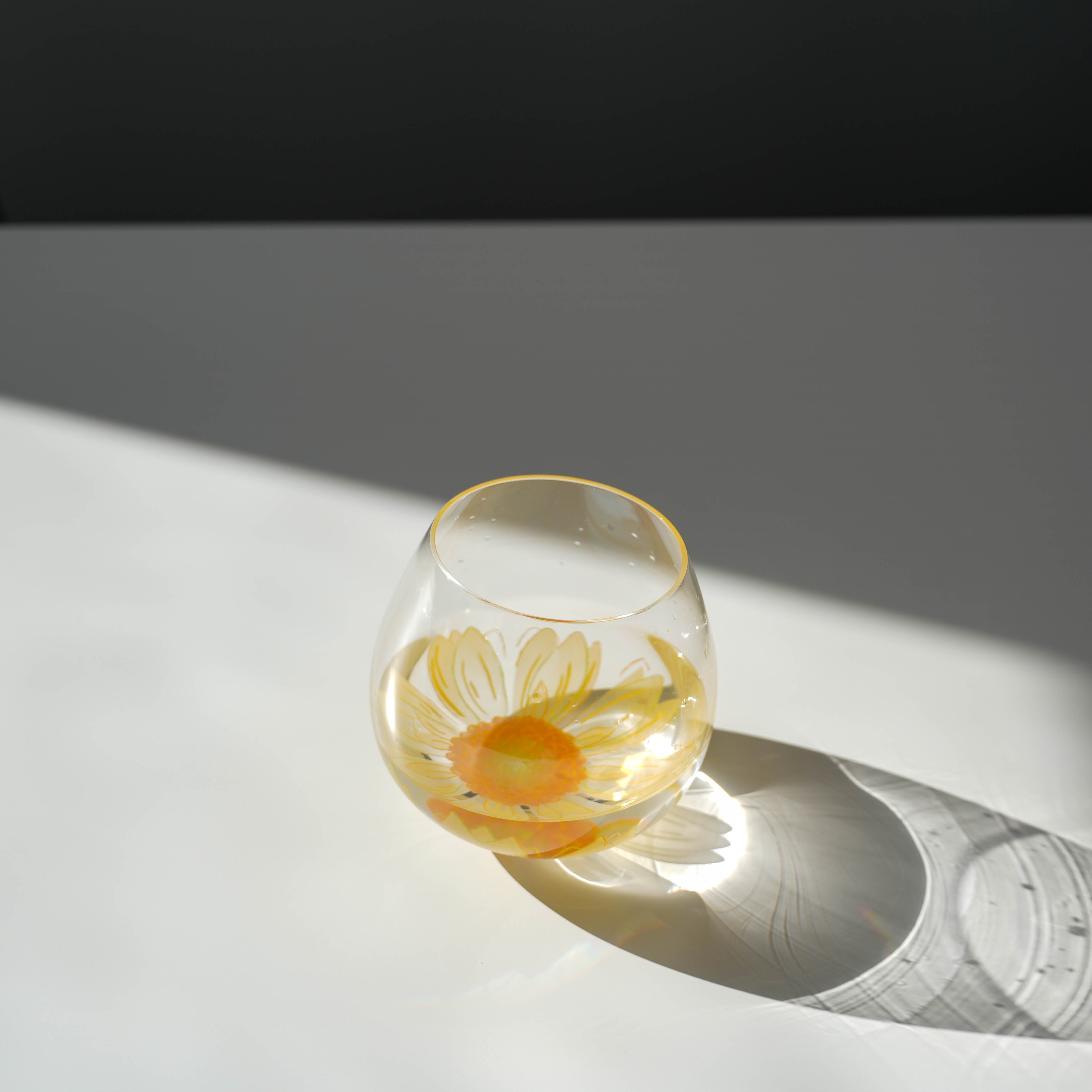 Toyo-Sasaki Tumbler - Fleurir Glass in sunlight, highlighting the vibrant yellow Gerbera flower and elegant curved silhouette.
