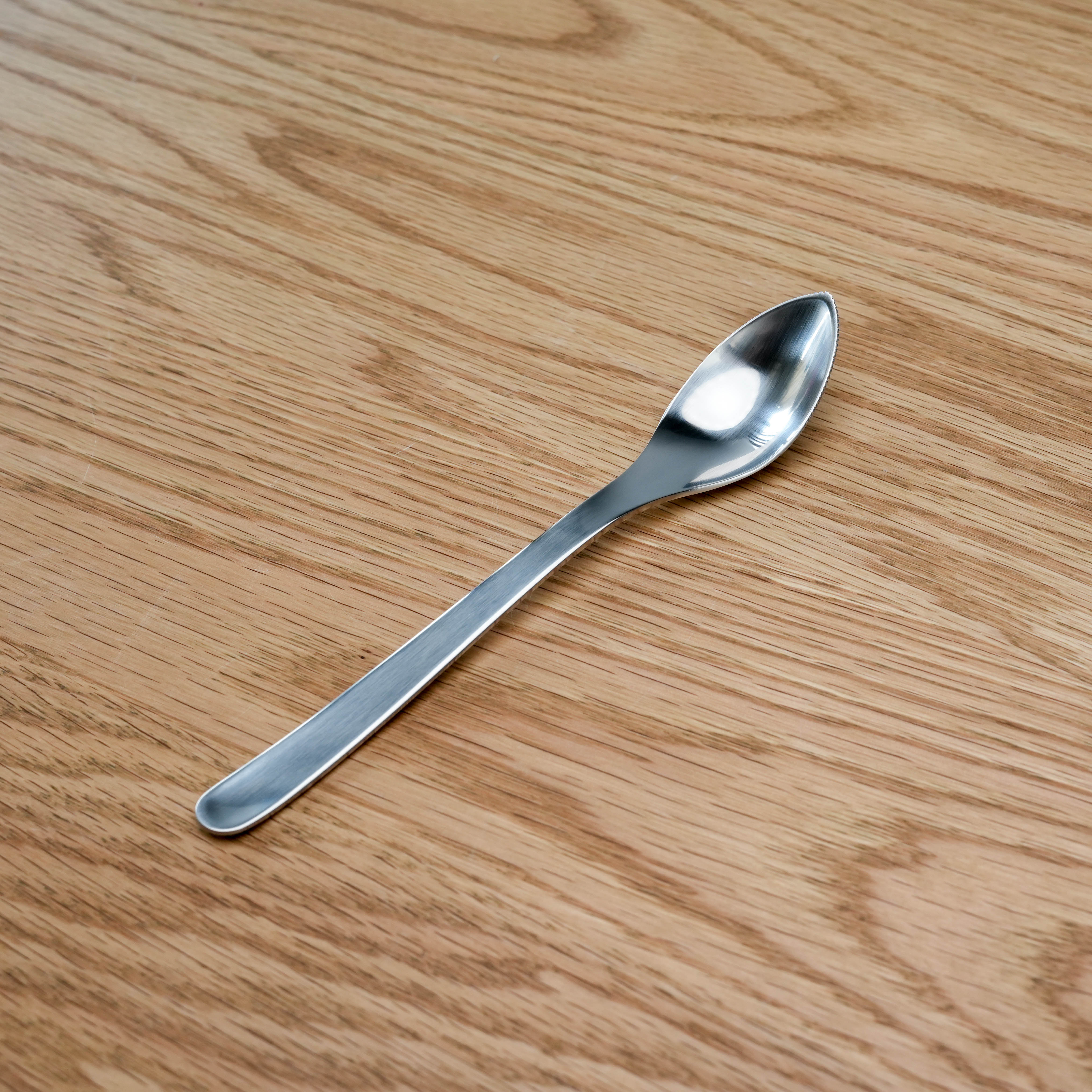 Sori Yanagi Grapefruit Spoon - Stainless Steel | Japanese Design shown on wood surface with sleek, ergonomic handle for modern kitchen use.