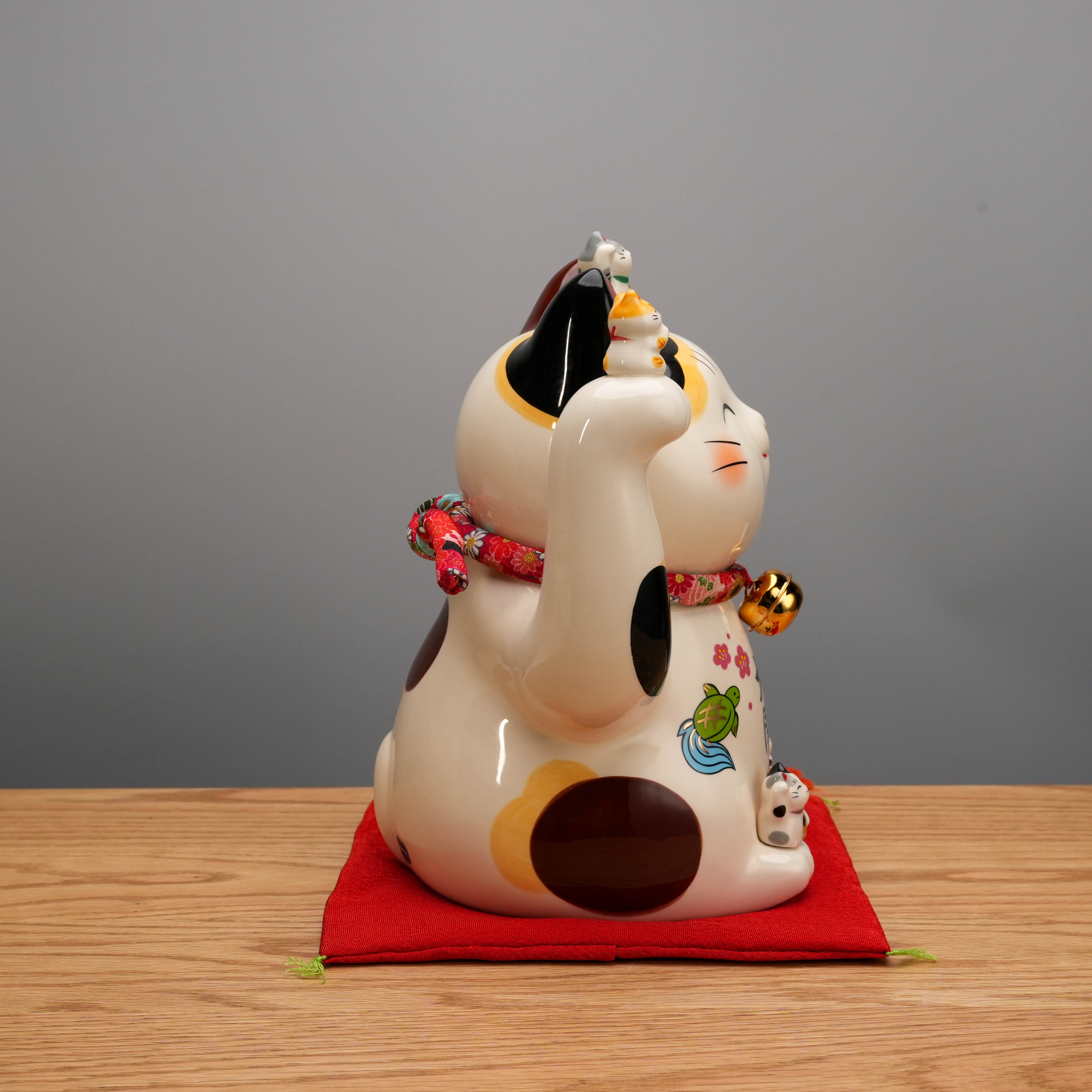 Right profile of Yakushigama Bliss Beckoning Cat with intricate painted details and smaller cats on head, perfect for welcoming guests with luck.