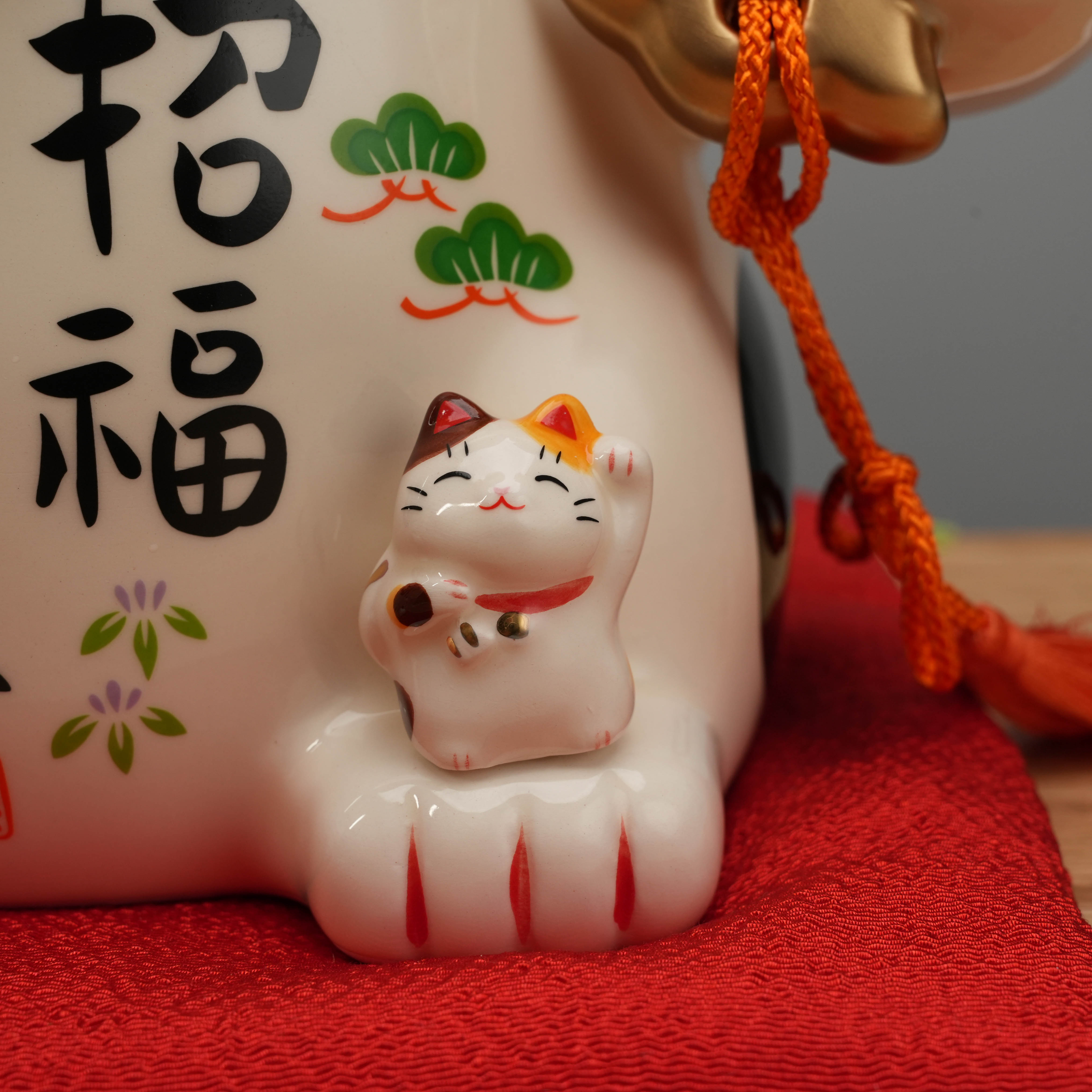 Detailed view of miniature cat on Yakushigama Bliss Beckoning Cat’s foot, adding layered symbolism of happiness and good fortune.
