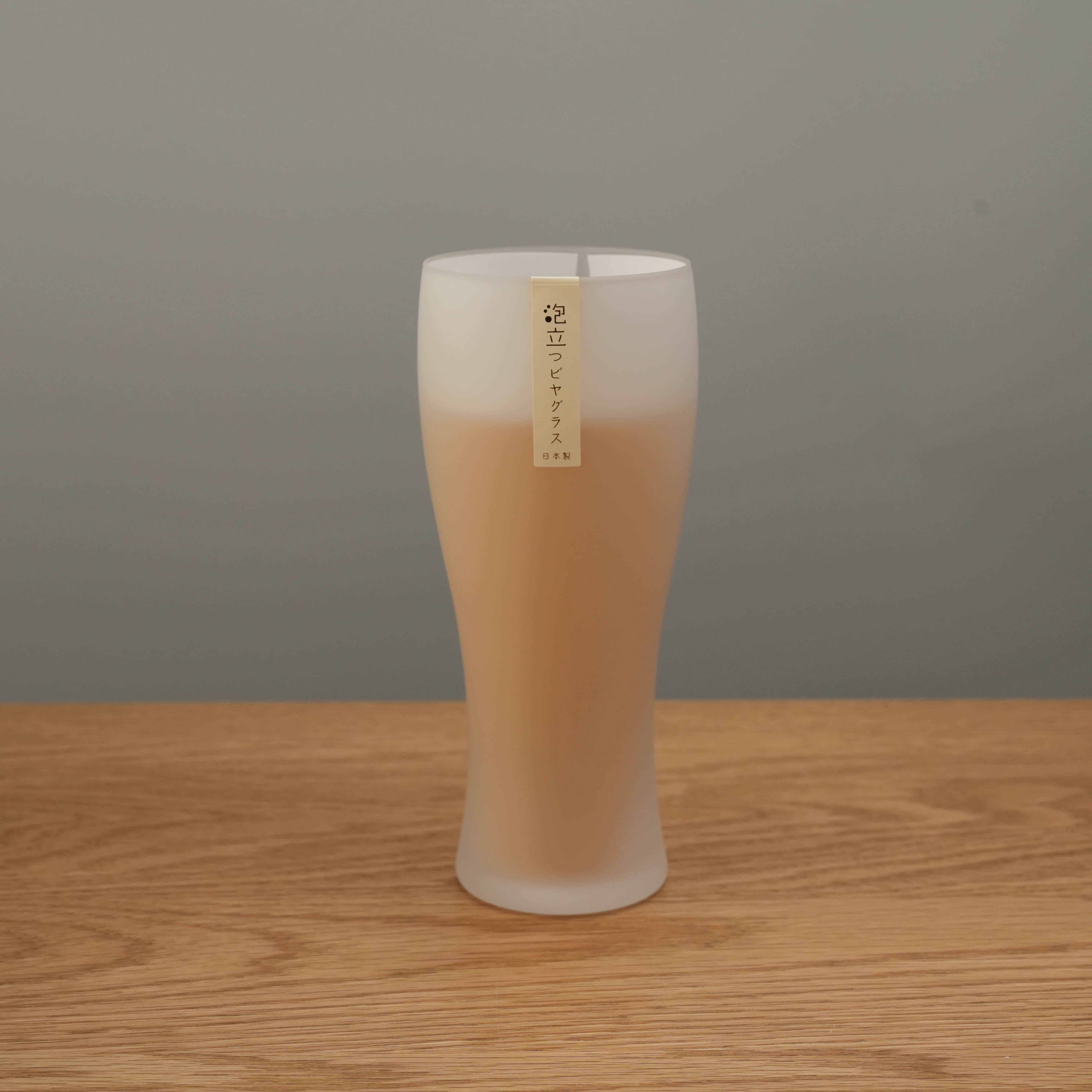 Toyo-Sasaki Frosted Glass Schooner Beer Glass with creamy beer inside, showcasing its smooth frosted finish and elegant silhouette. Ideal for enhancing beer foam.