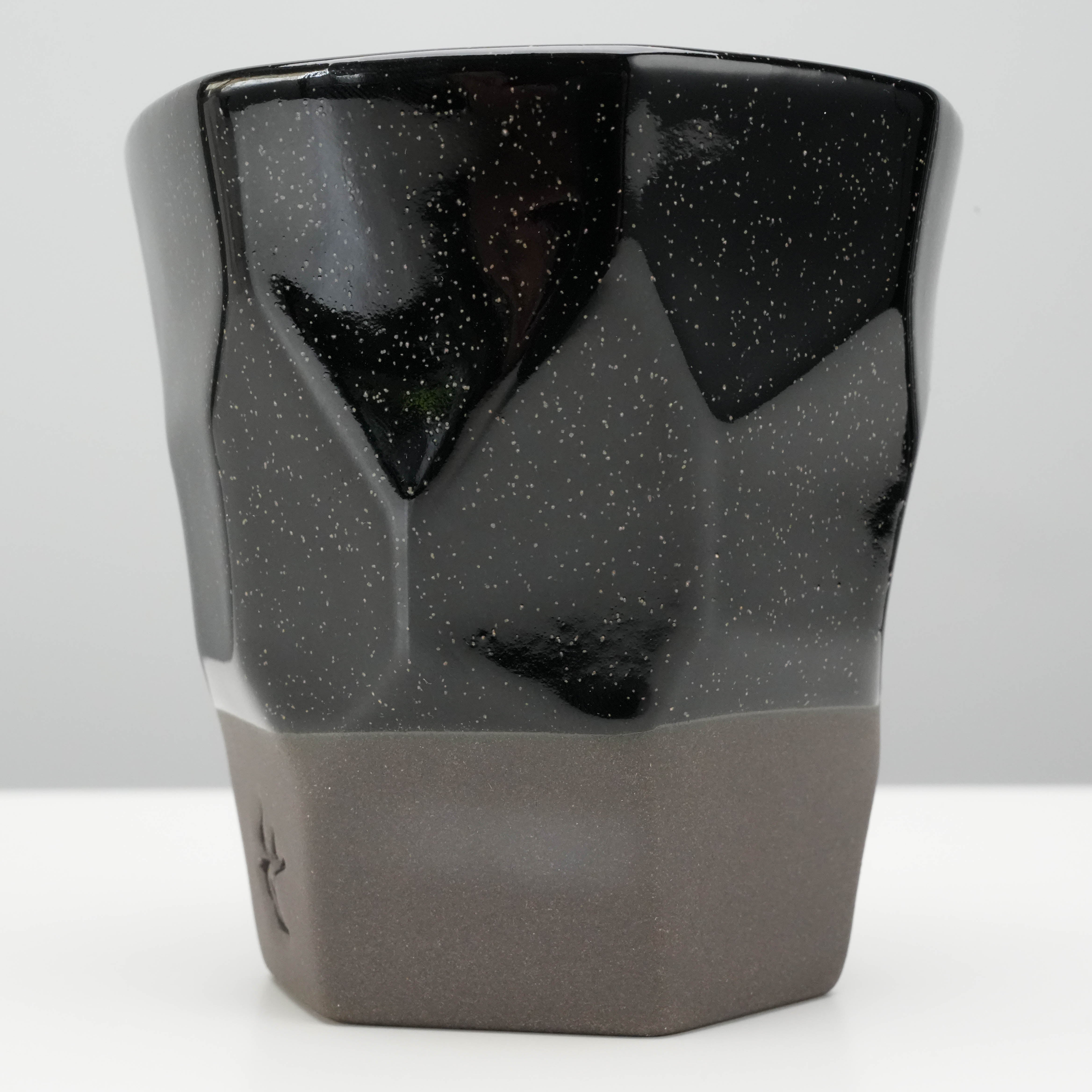Detailed view of Tsubame Kobo Free Cup’s geometric black clay body with speckled glaze, 220ml capacity for stylish drinkware.
