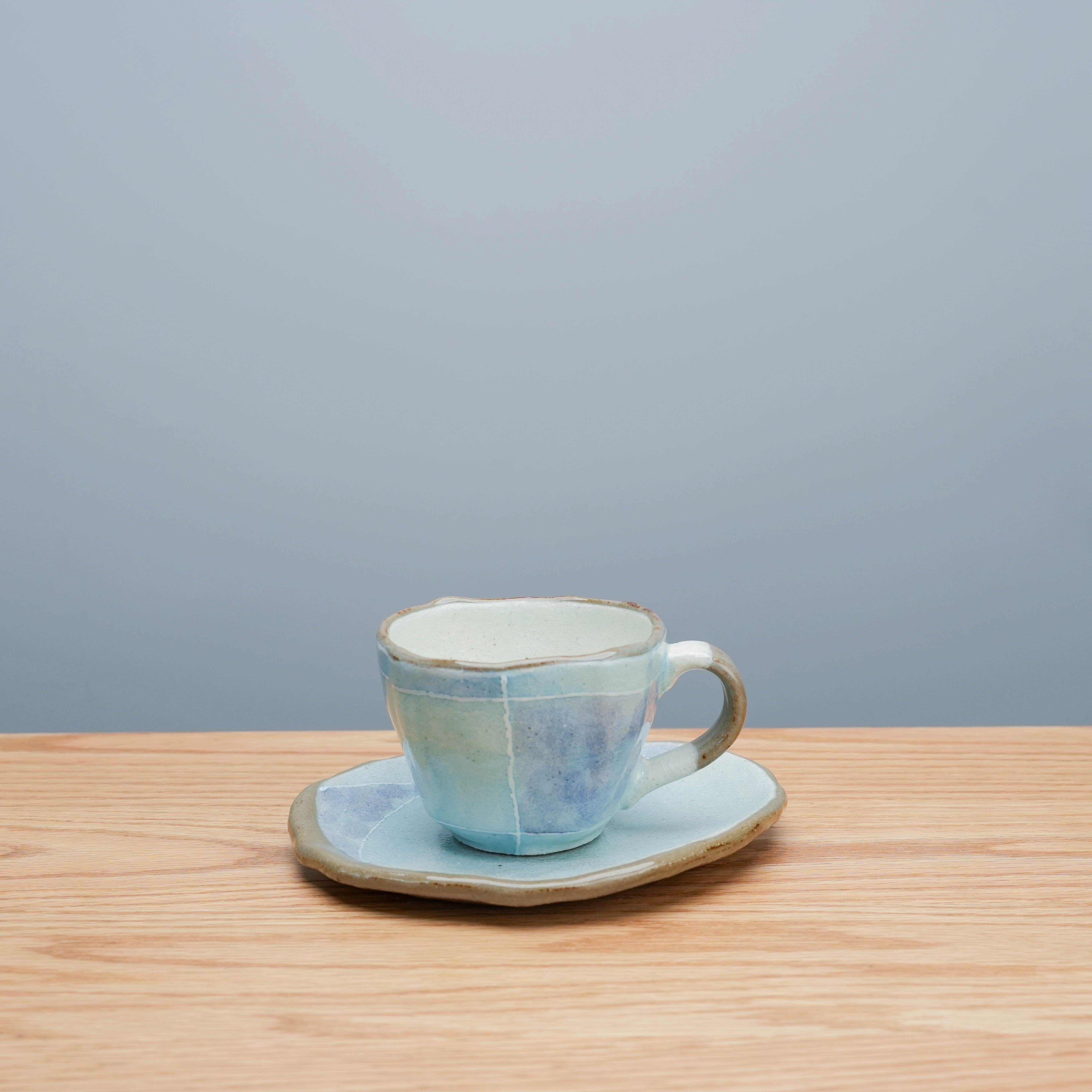 Tokiwa Mino Ware Cup & Saucer - Coffee Cup with Saucer | Handmade ceramic blue Tatara cup and saucer set on wooden table, ideal for tea or coffee.