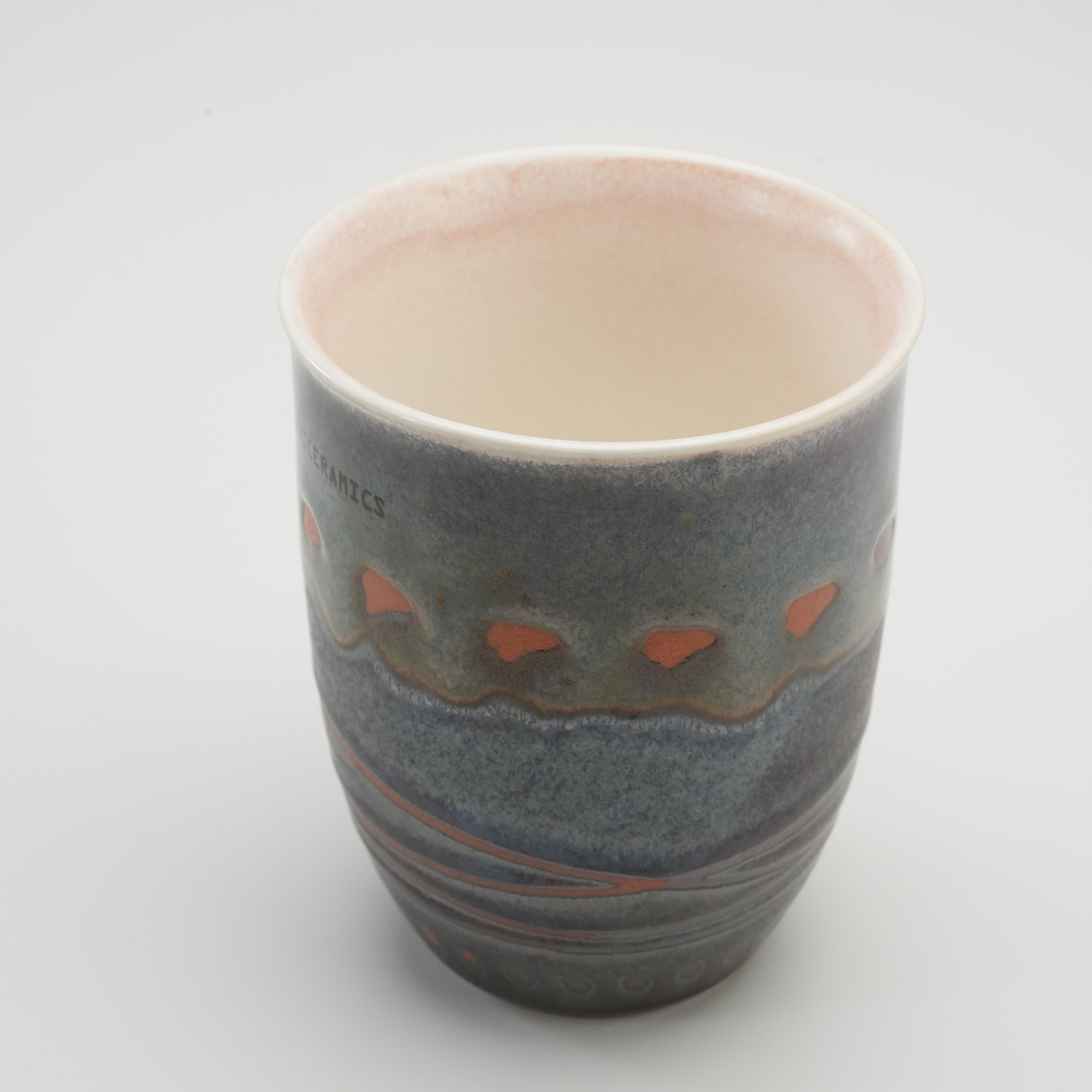 Open top view of Handiceramics Acorn Travel Cup, revealing smooth glazed interior and detailed handcrafted exterior in earthy tones.