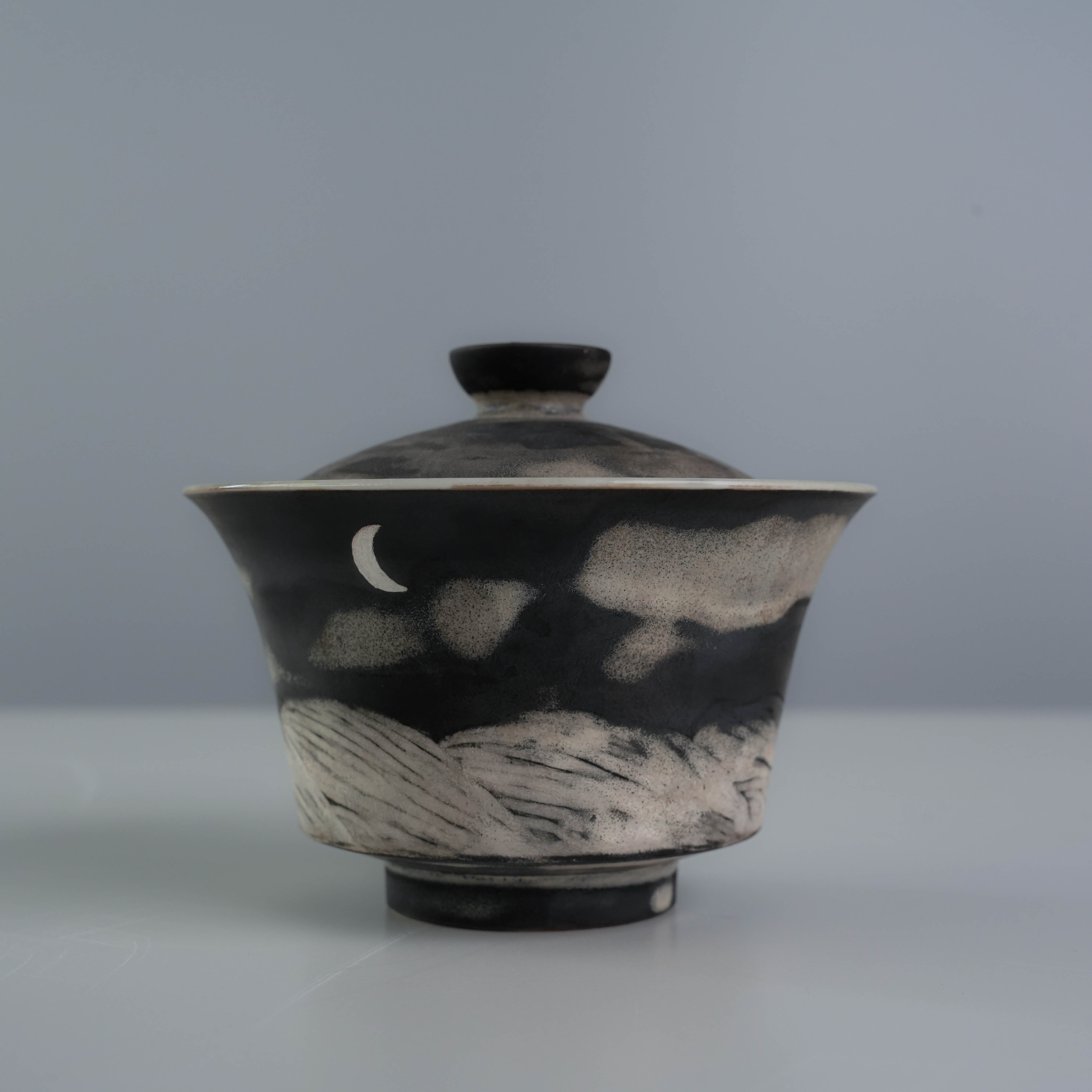 Lidded gaiwan from the Lonesome Studio Qushui Tea Set, handmade with silver glaze and moonlit mountain design for Gongfu Cha rituals.