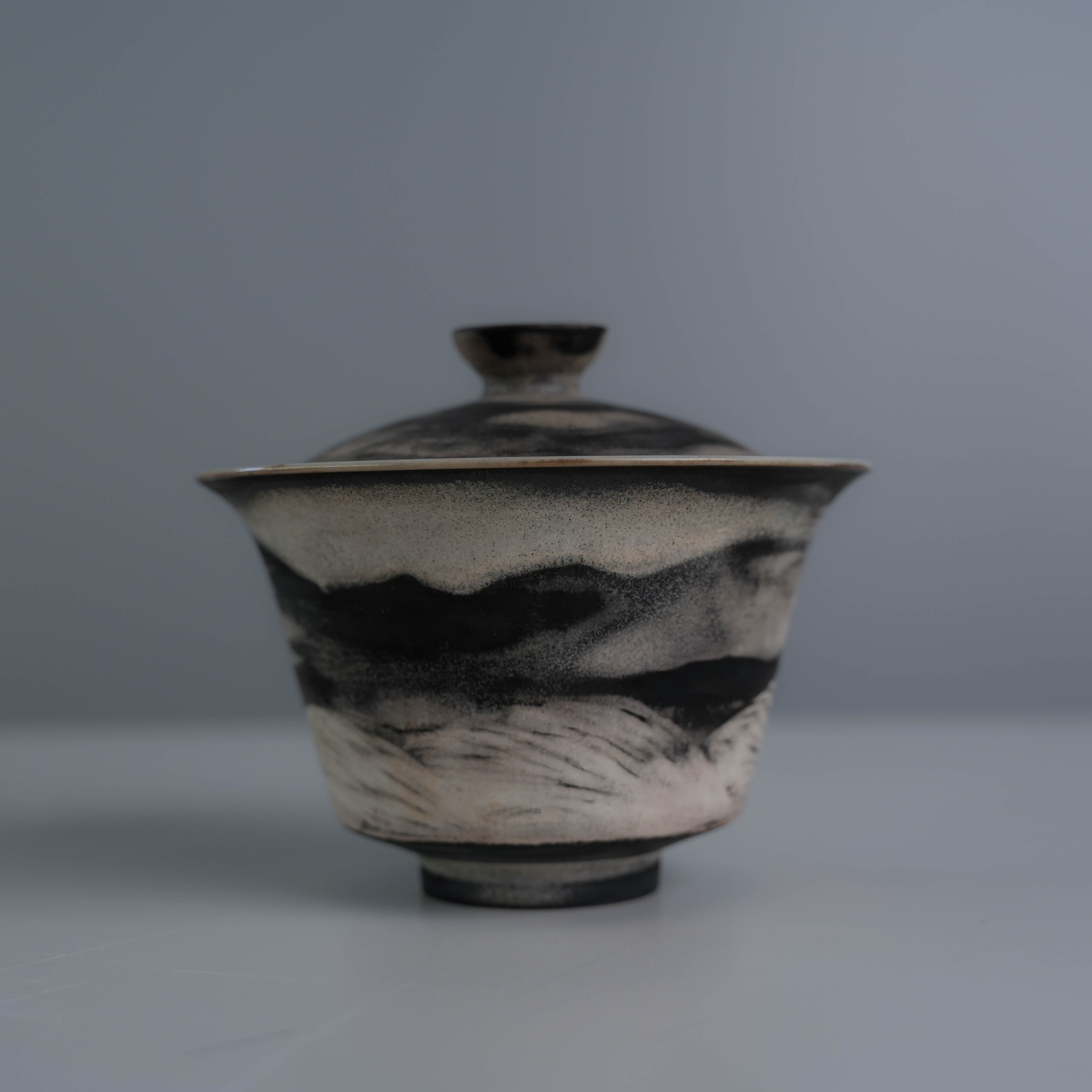 Back view of Lonesome Studio Qushui gaiwan showing hand-painted mountain landscape, part of silver glaze Gongfu Cha tea set.