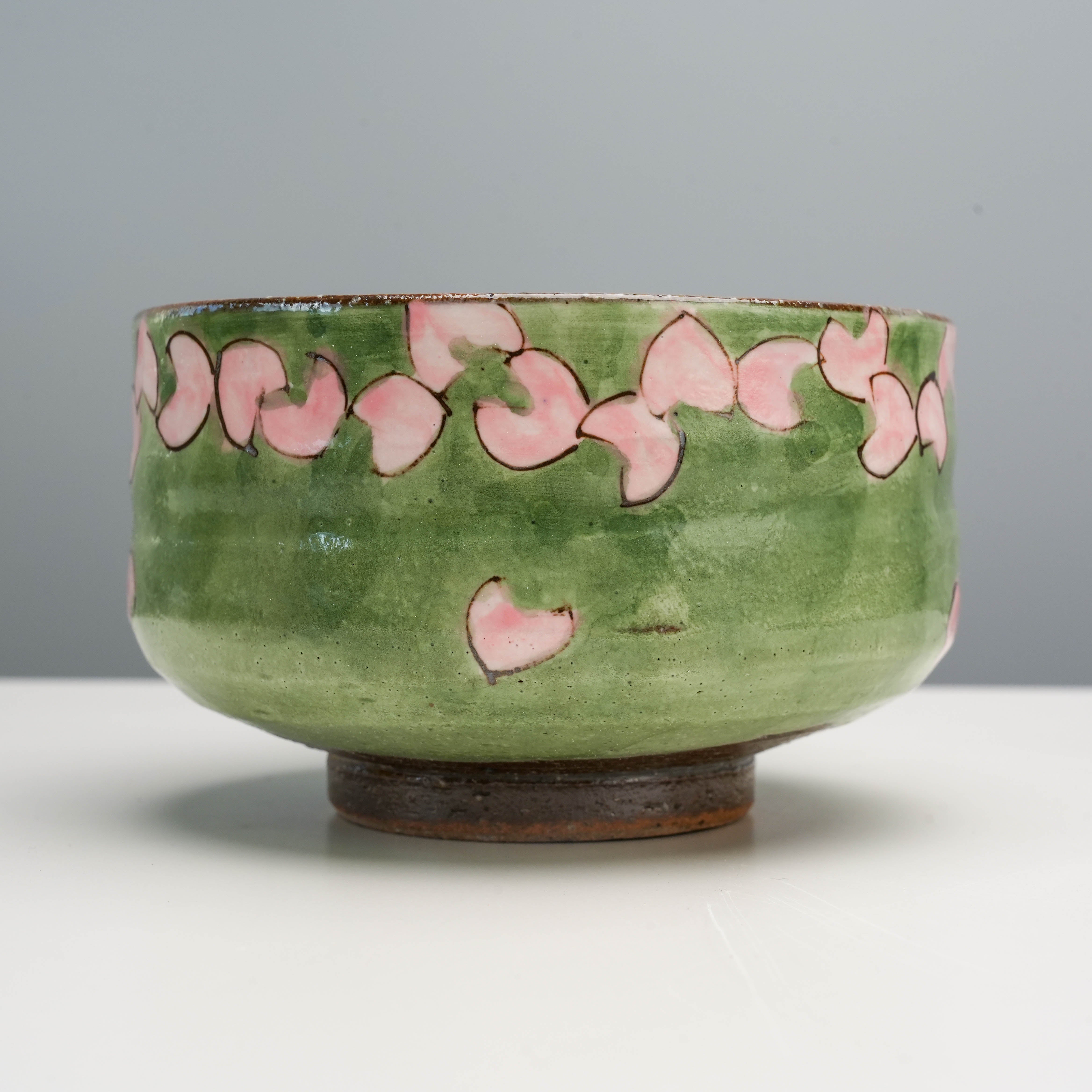 Side view of Kutani Ware Matcha Bowl with delicate pink cherry blossom petals, a serene addition to any teaware or dinnerware collection.