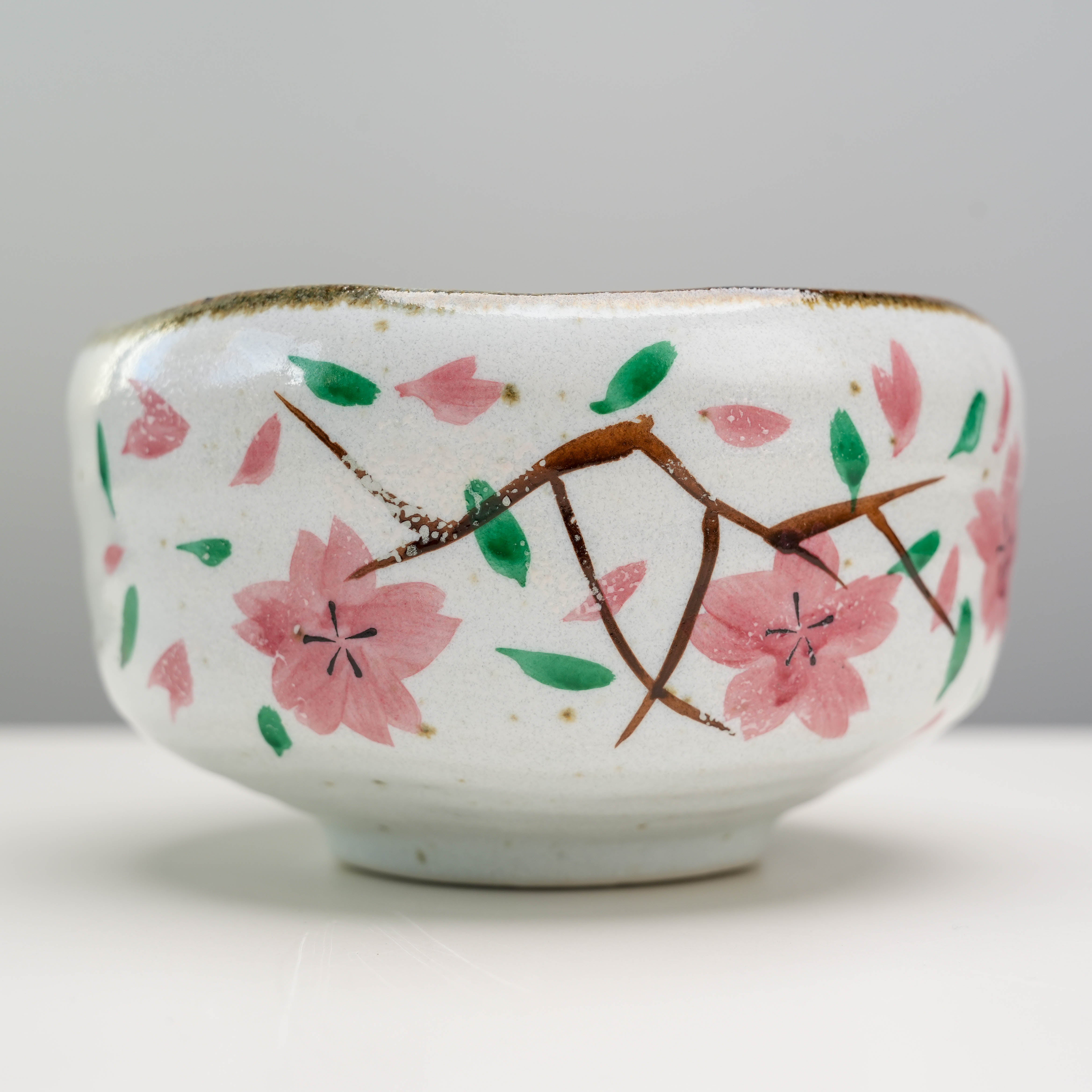 Close-up of hand-painted cherry blossom design on Mino Ware Matcha Bowl, highlighting artisanal craftsmanship and natural aesthetics.
