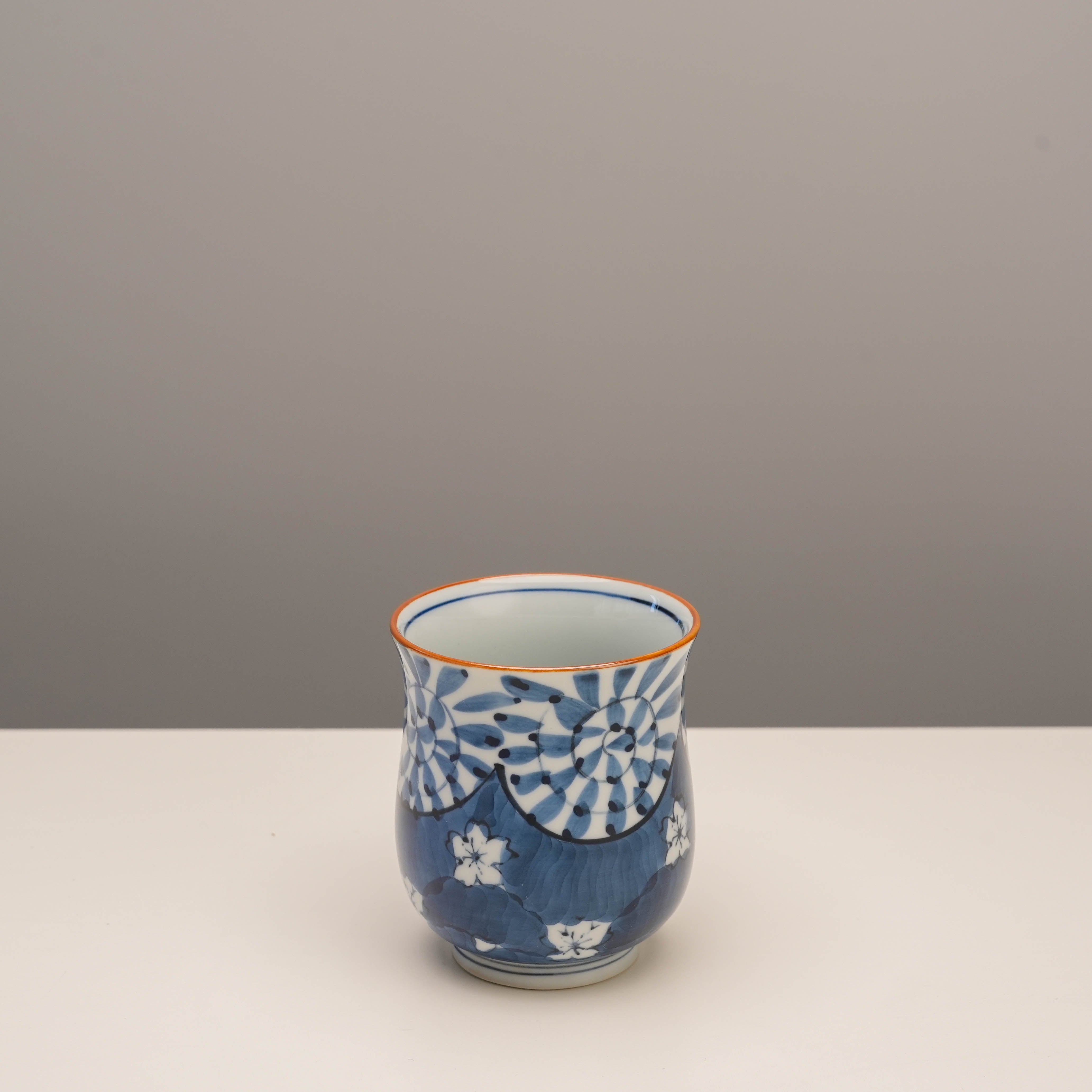 Compact view of blue Arita Ware Yunomi tea cup showcasing detailed cherry blossom and arabesque patterns. Ideal for traditional tea rituals.
