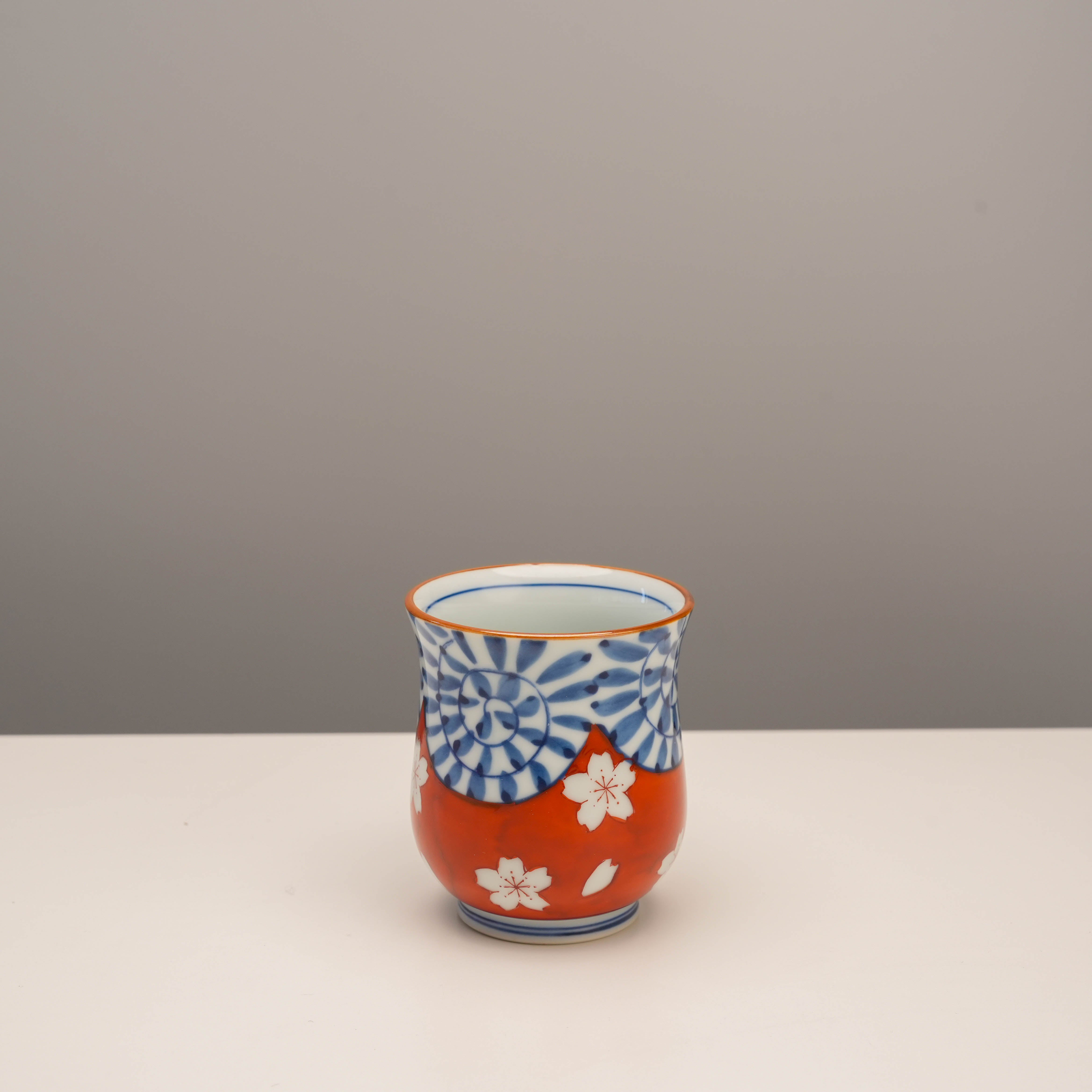 Smaller red Arita Ware tea cup with vibrant cherry blossom and arabesque design. Perfect for Japanese tea ceremonies or decor.