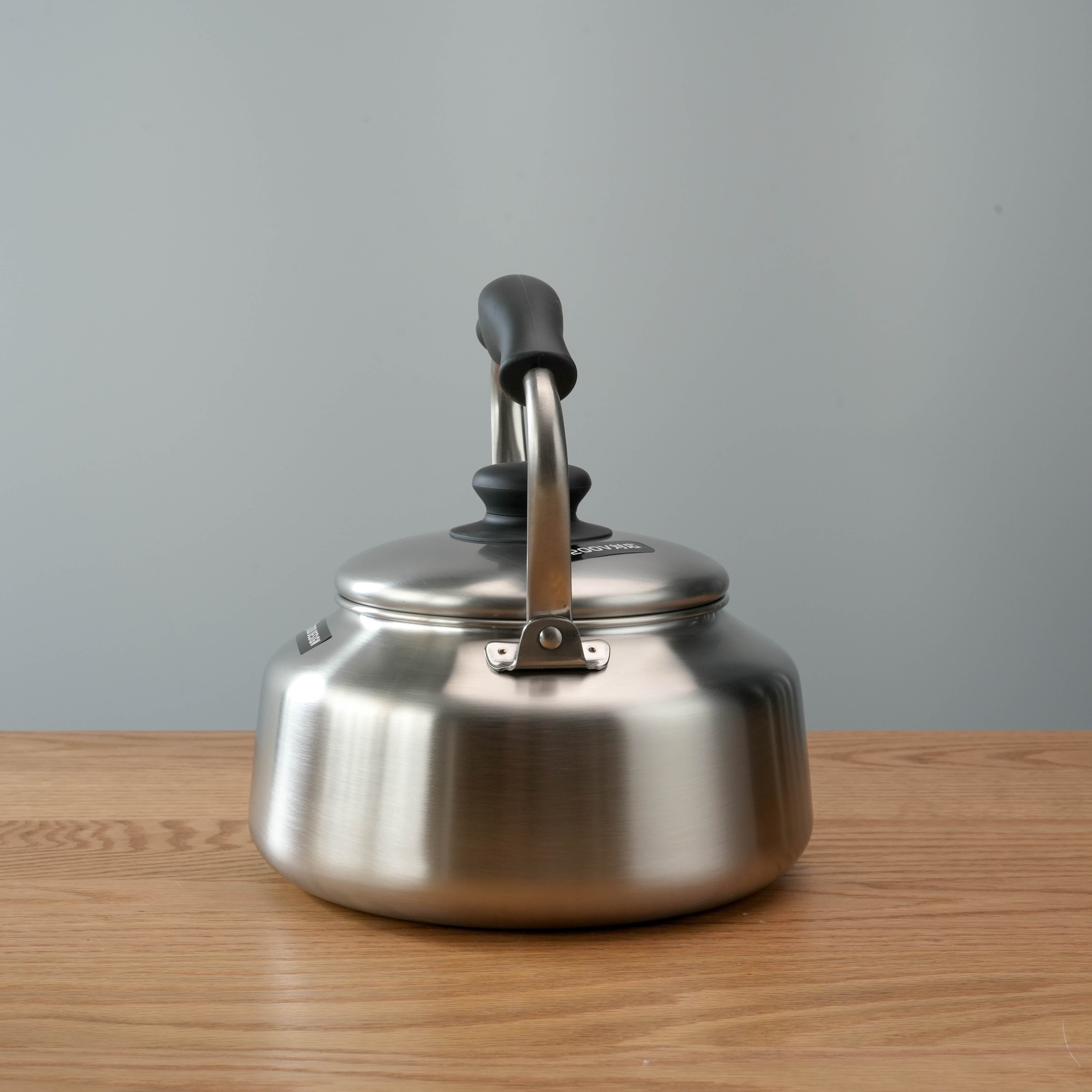 Rear view of Sori Yanagi Kettle - Stainless Steel Kettle with smooth matte finish and sturdy riveted handle for safe pouring.