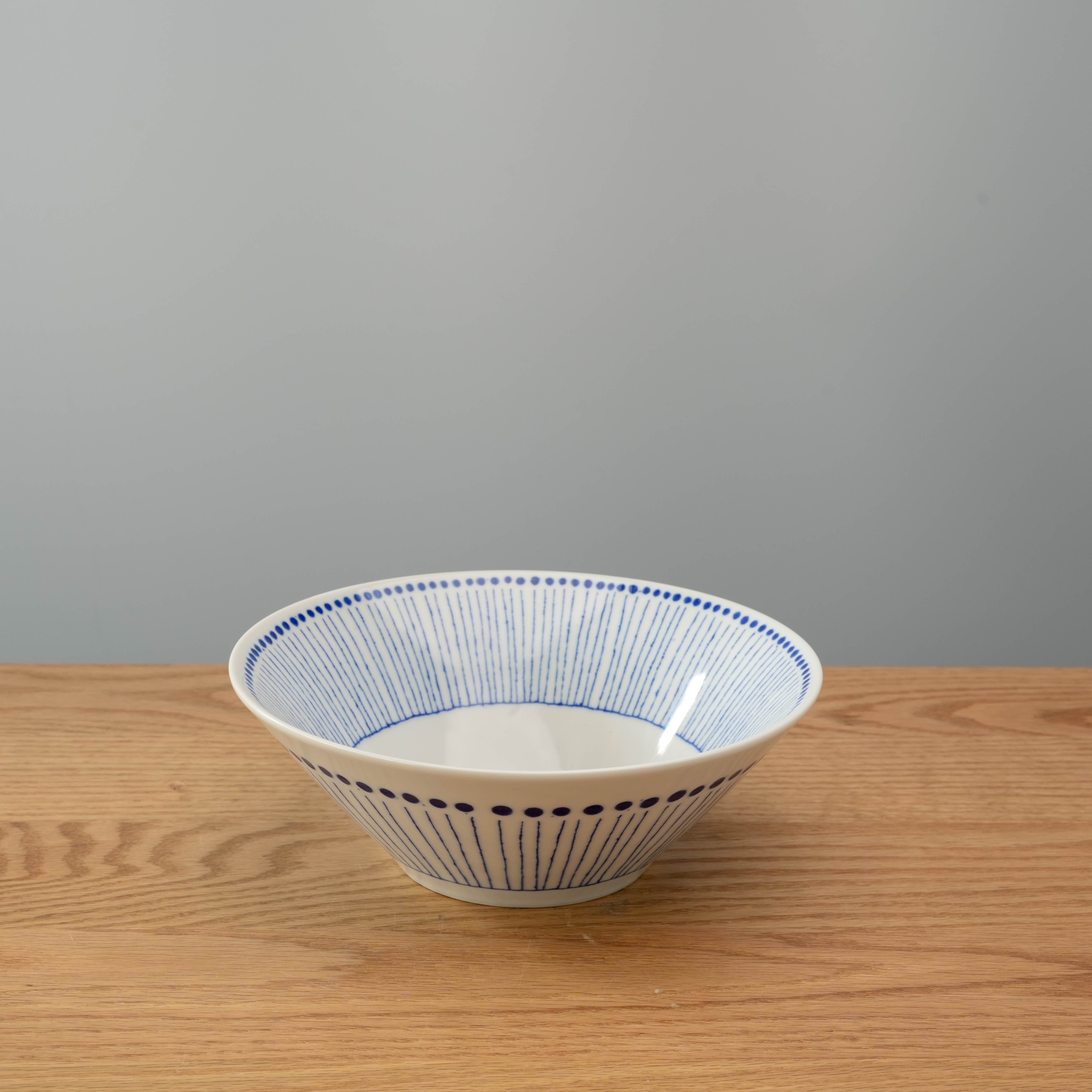 Blue Tokusa Dot Bowl with indigo stripes and dots, Mino Ware design, ideal for serving noodles. Elegant 7.0 size ceramic bowl on wooden table.