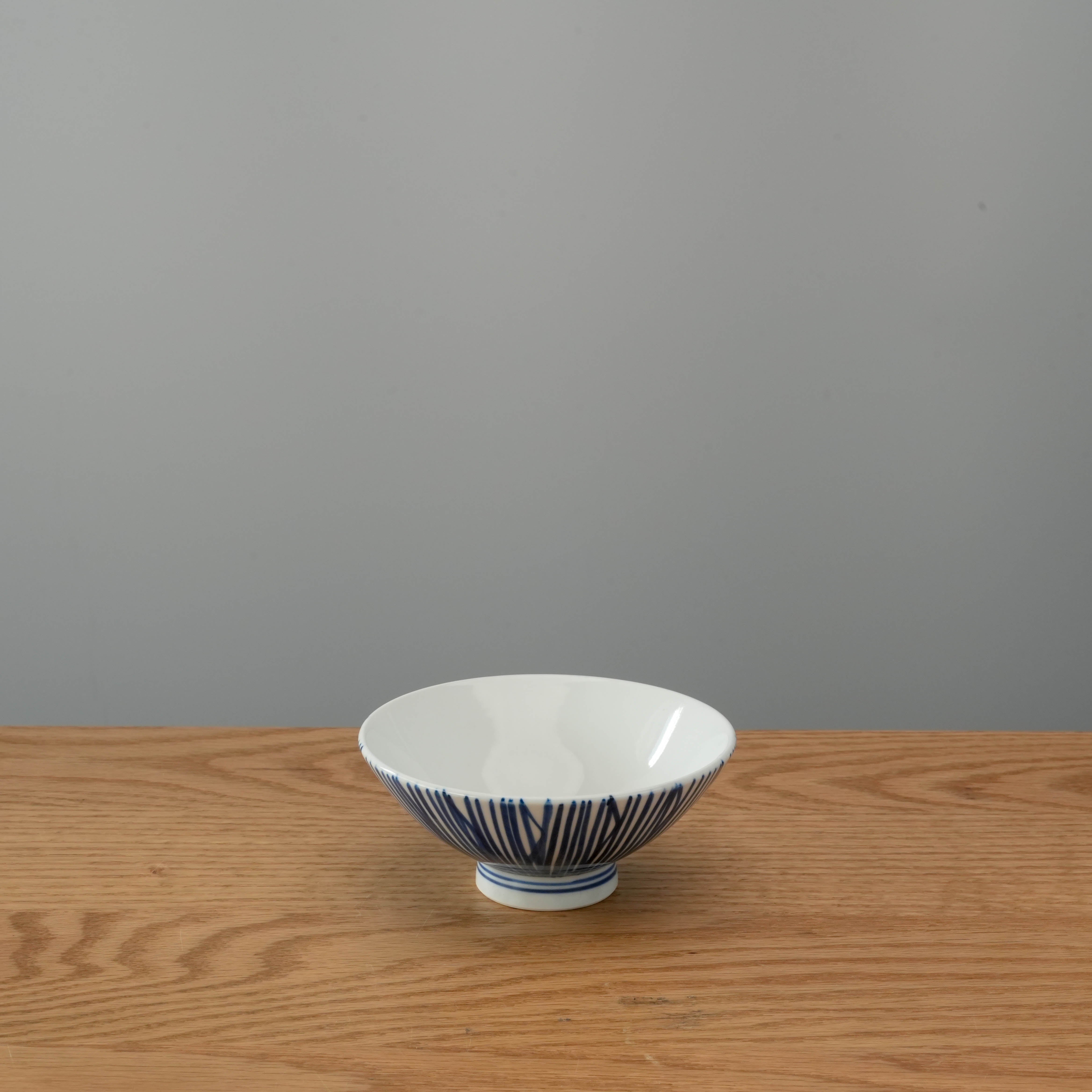 Mino Ware Rice Bowl with fine indigo sensuji lines, Japanese ceramic bowl ideal for rice, featured on a wooden surface.