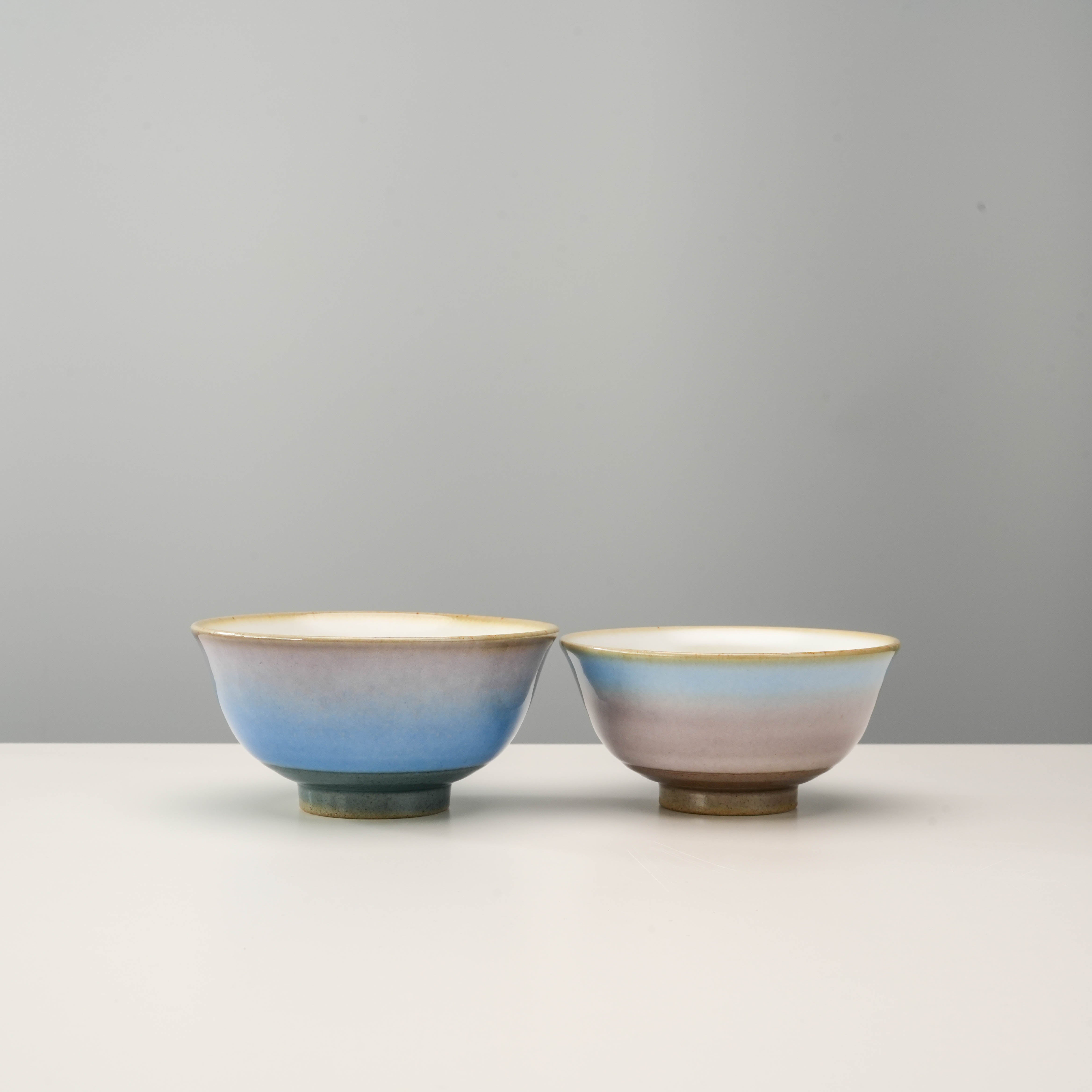 Kutani Ware Rice Bowls - Yusai Glaze Set featuring two handcrafted bowls with serene blue and pink gradients, ideal for gifting or couples.