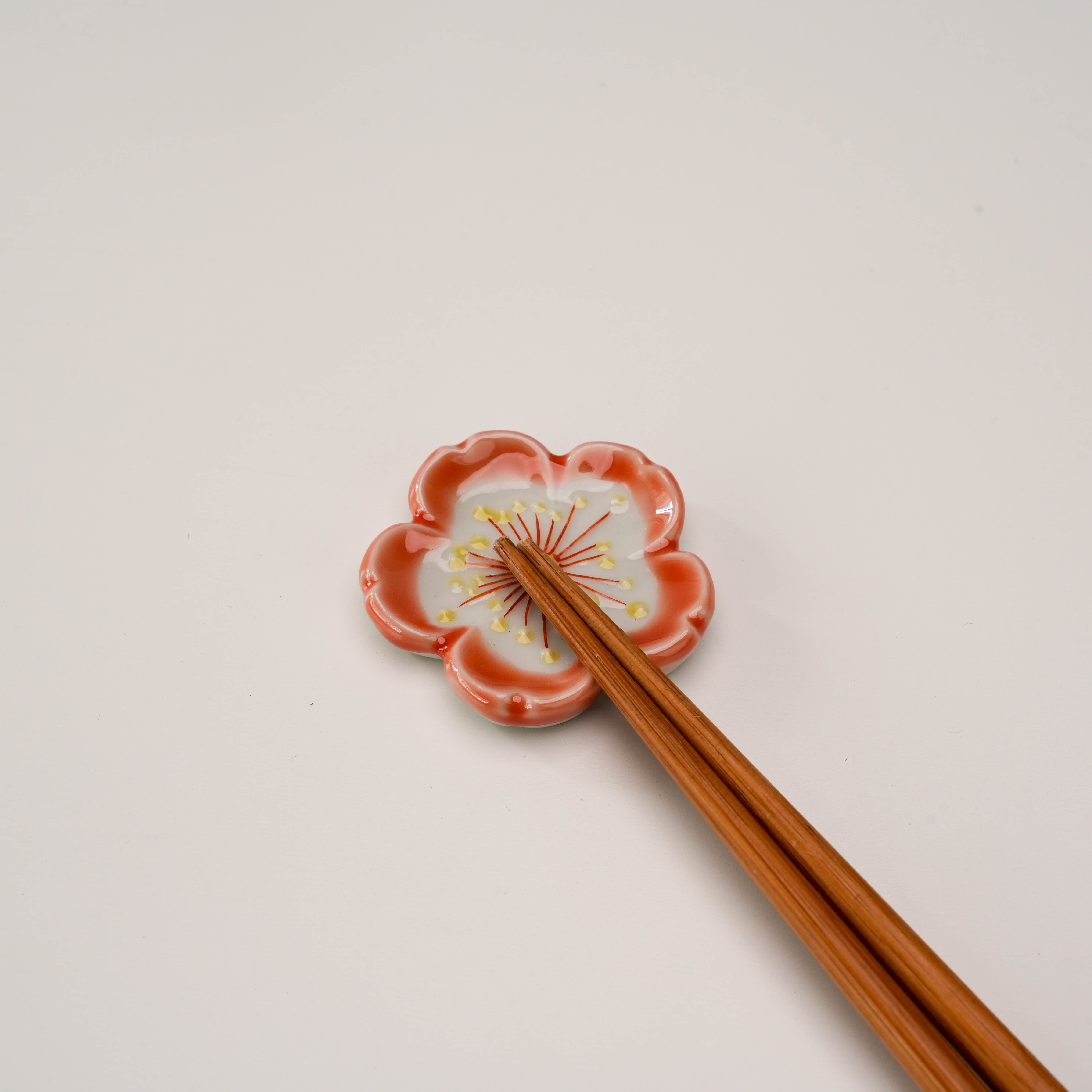 Single Kutani Ware Sakura chopstick rest in use, showcasing floral design with wooden chopsticks, perfect for enhancing dining presentation.