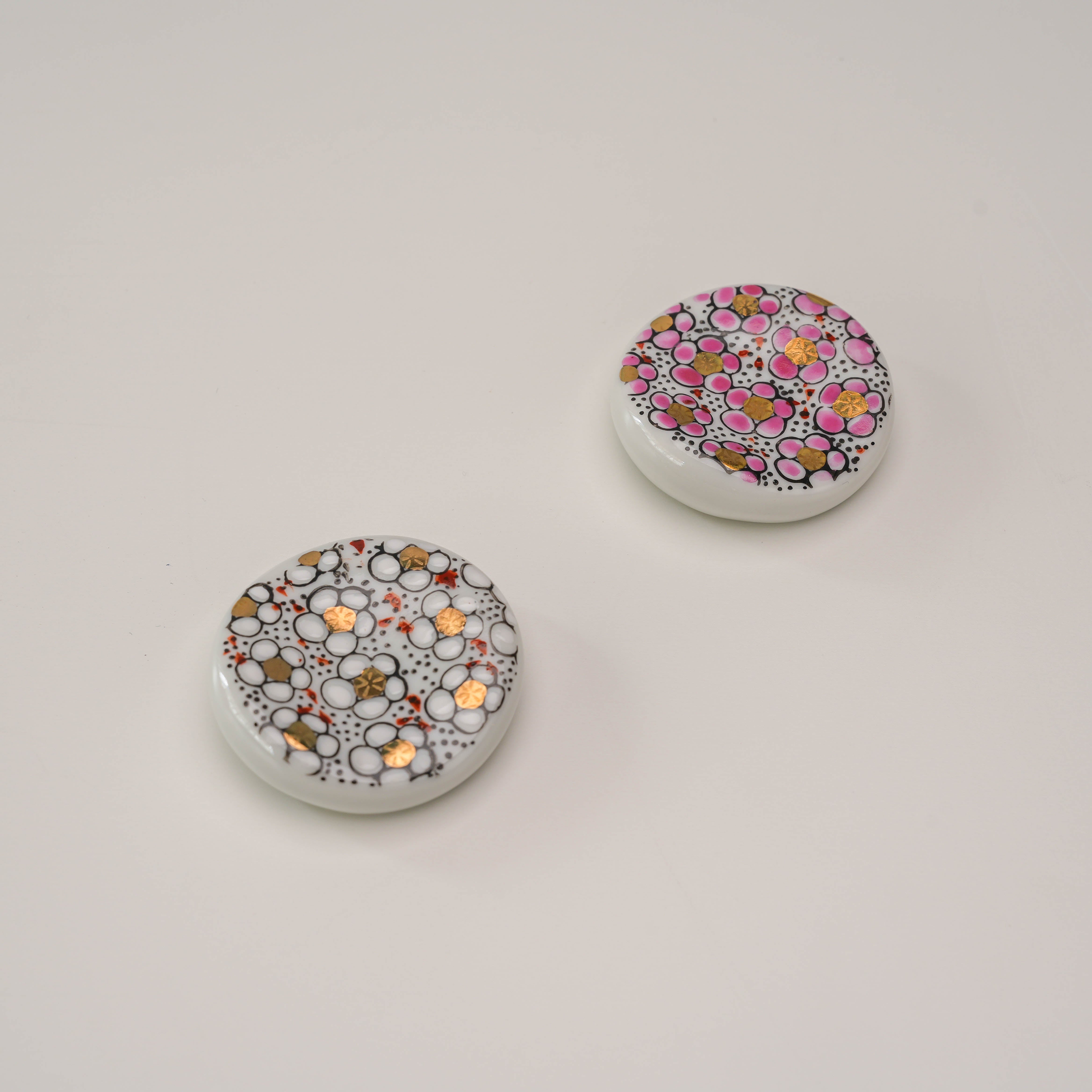 Kutani Ware Chopstick Rest - Plum Blossom Set of 2 featuring circular ceramic rests with intricate gold, pink, and white floral patterns.