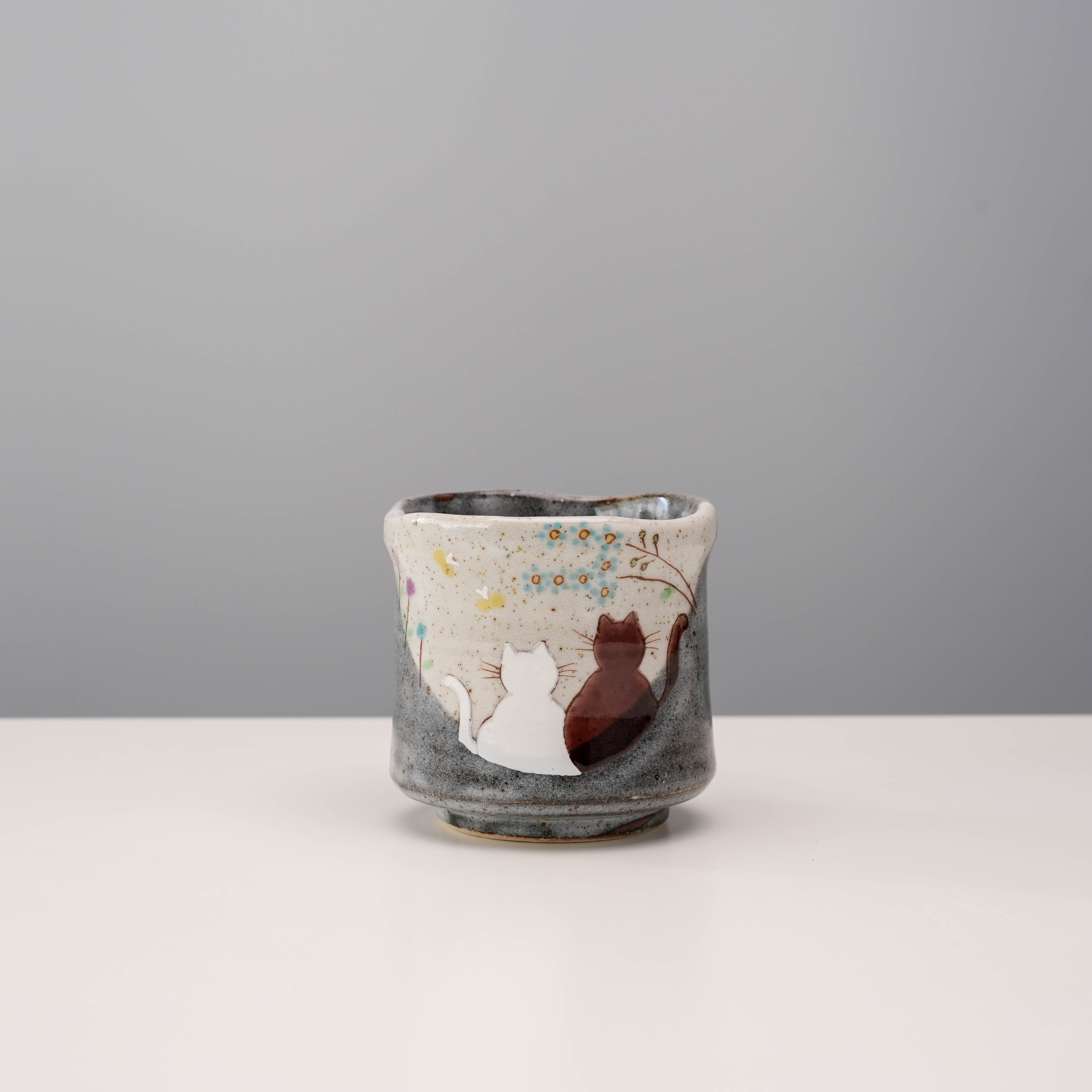 Kutani Cat Yunomi Teacup with hand-glazed cats basking in sunlight, featuring earthy tones and floral accents. Ideal for tea lovers and collectors.