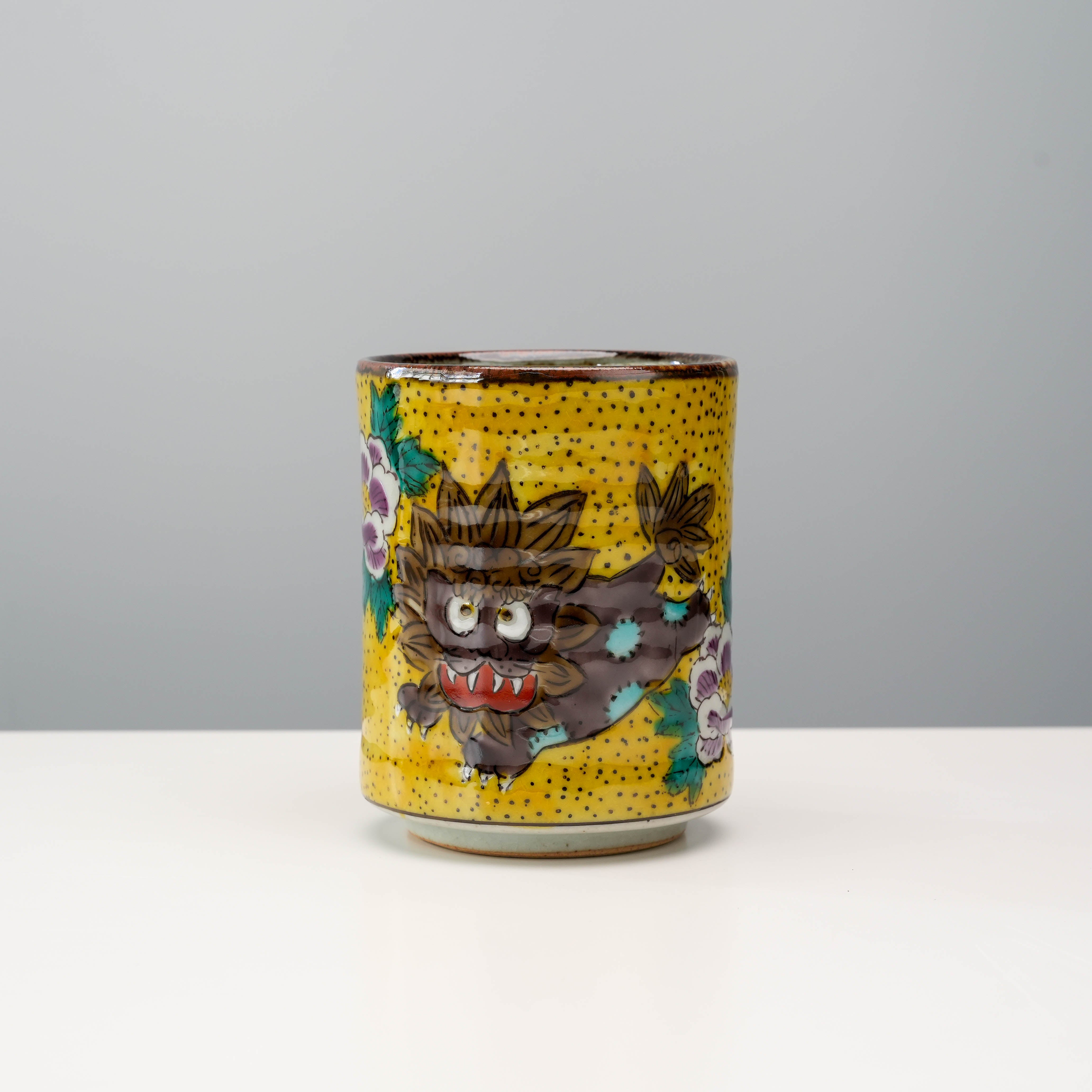 Kutani Ware Lion & Peony Teacup featuring a hand-painted Karajishi lion and peonies on a yellow speckled background, ideal for Japanese tea rituals.