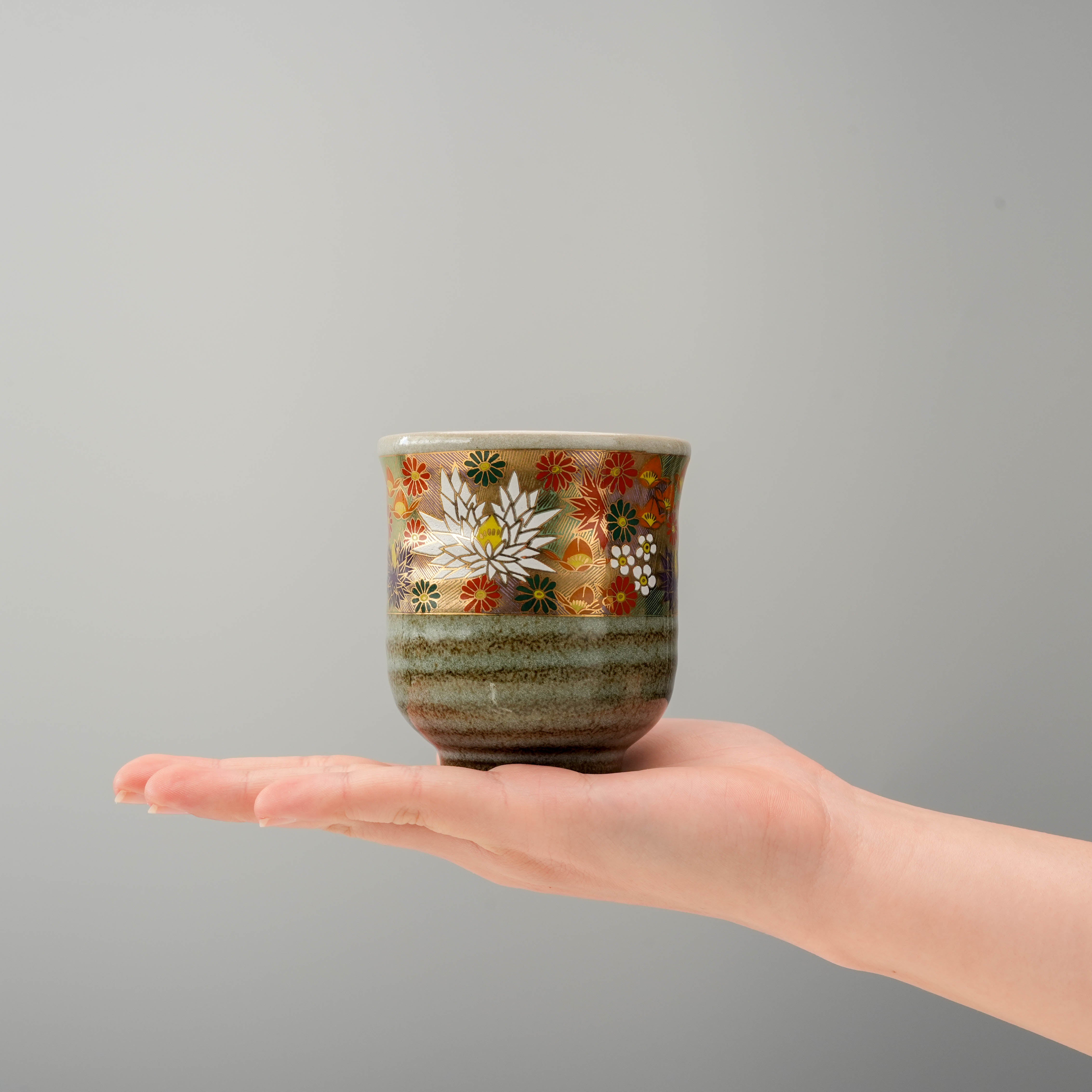 Kutani Ware Golden Garden Yunomi Teacup shown in hand for scale, highlighting its compact size and intricate floral design.